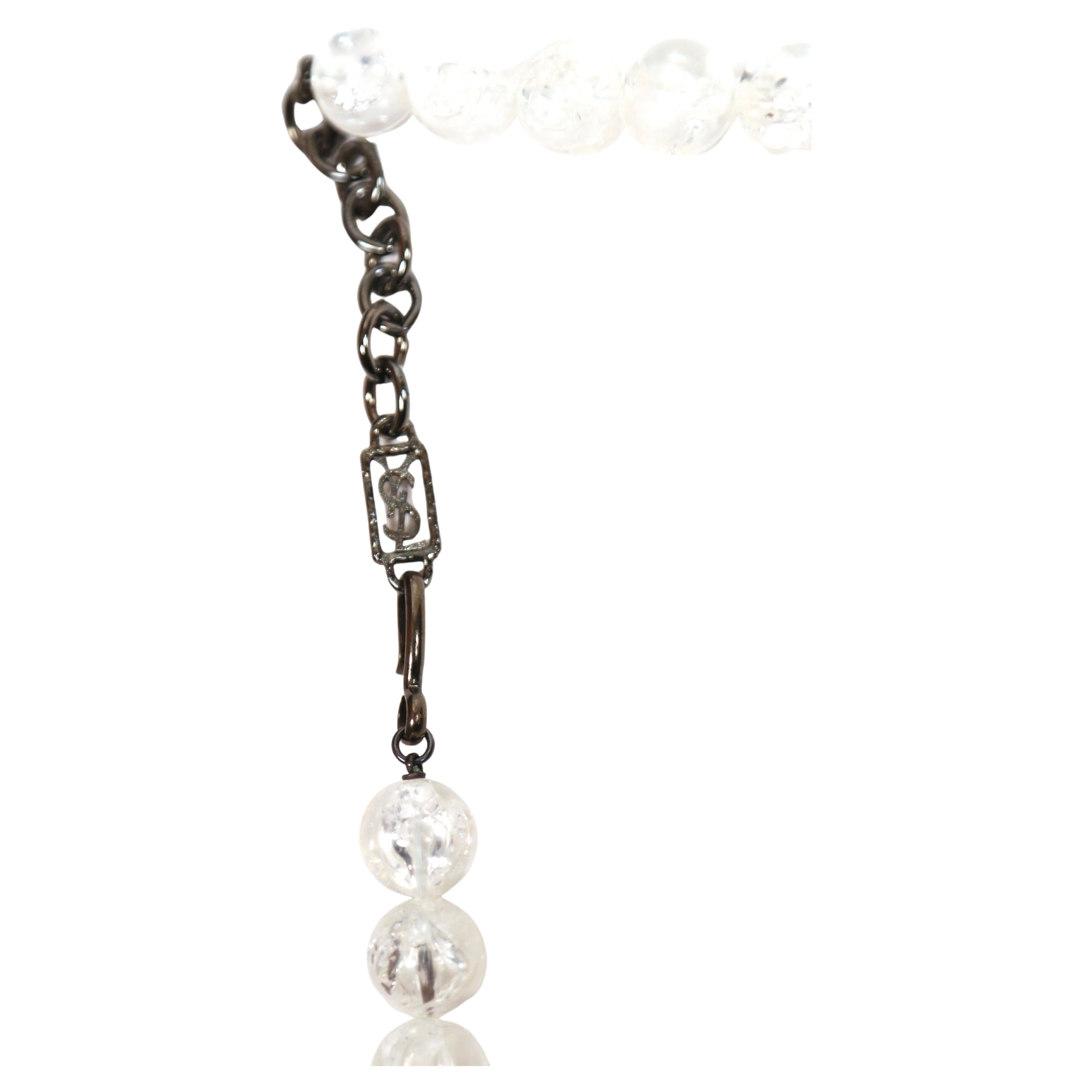 Dramatique collier en perles de lucite avec des feuilles émaillées crème et noir, en métal argenté, conçu par Yves Saint Laurent et datant du début des années 1990. La longueur est réglable d'environ : 15-17.5