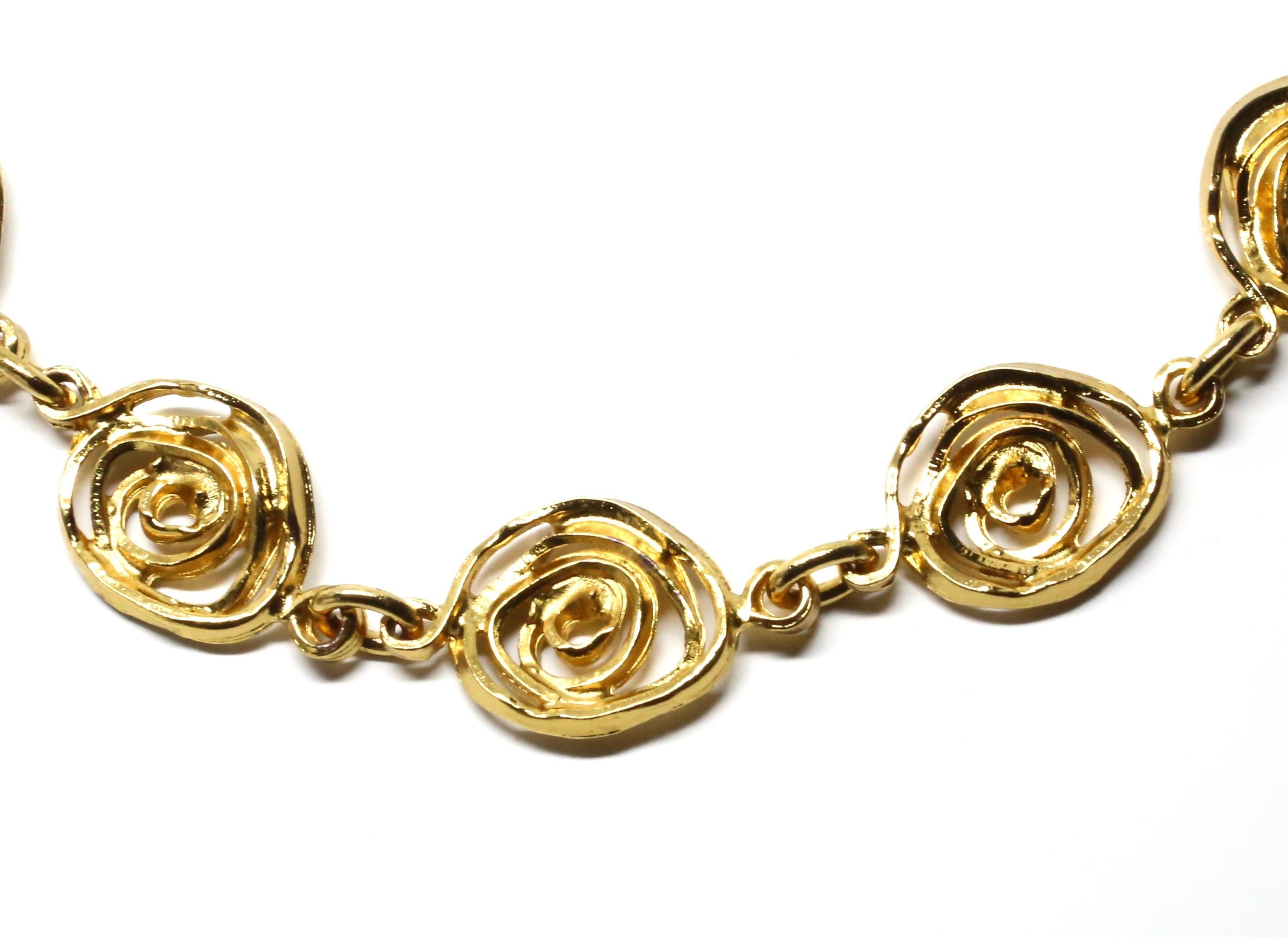 Collier en métal doré avec un motif abstrait de roses conçu par Yves Saint Laurent dans les années 1990. Longueur réglable de 18,5 à 20 pouces. Fermeture à ressort lourd. Fabriqué en France. Excellent état.
