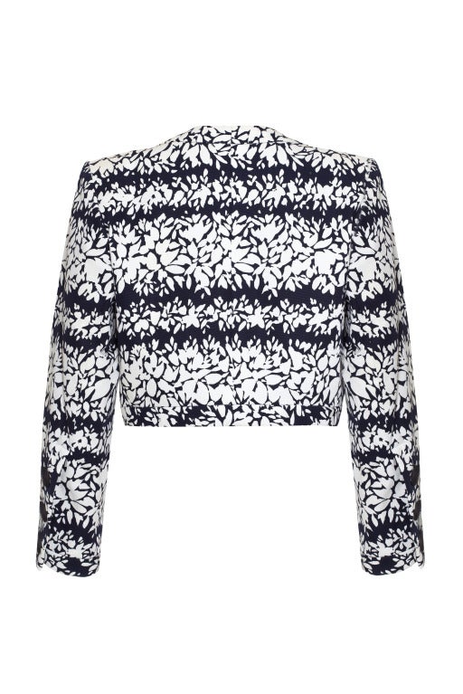 Cette élégante veste boléro Yves Saint Laurent du début des années 1990 est une pièce merveilleusement diversifiée et d'excellente qualité. La veste est composée d'un tissu de coton résistant et présente un imprimé floral abstrait de couleur marine