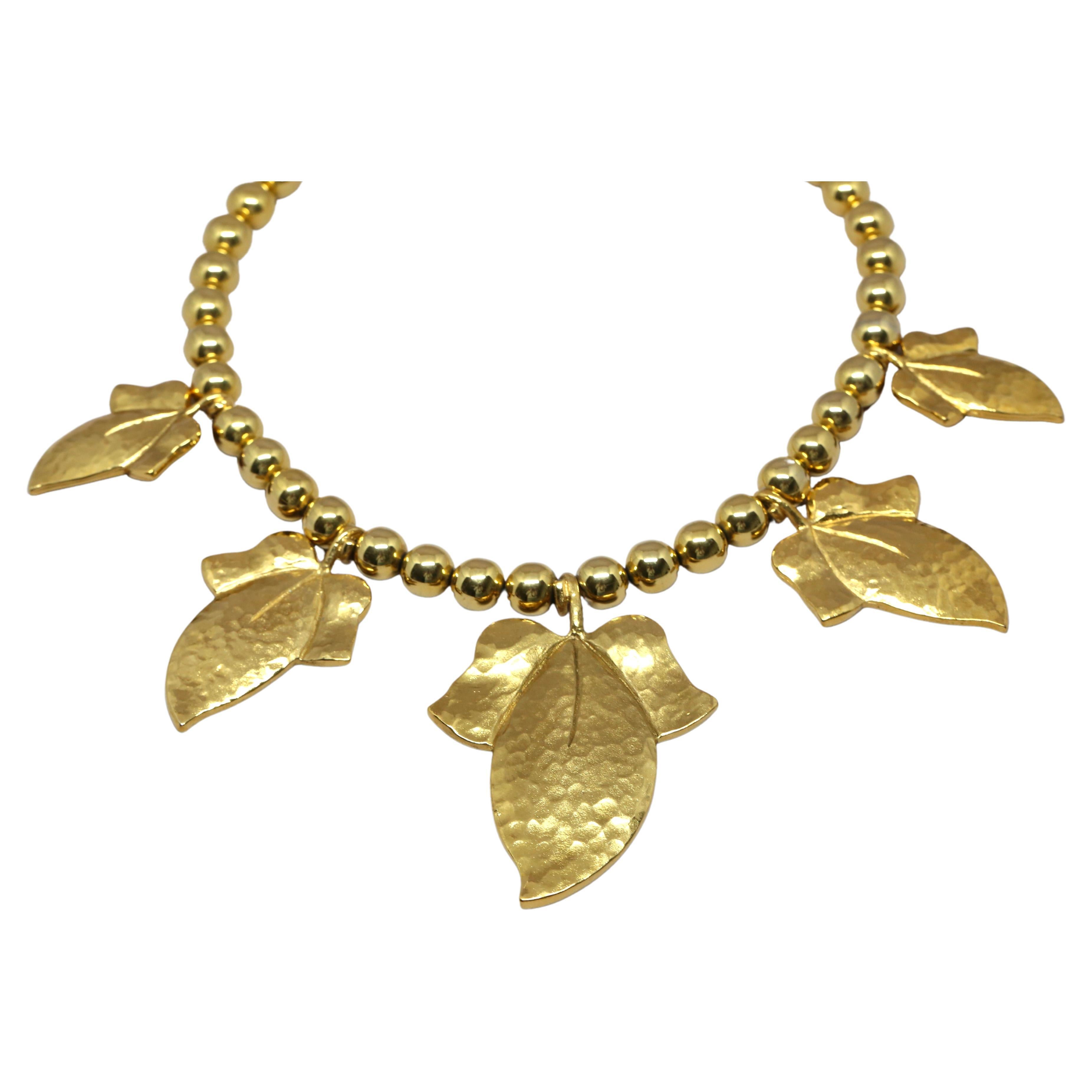 Oversized, gilt beaded necklace with hammered leaf charms from Yves Saint Laurent dating to the 1990's.  Adjustable heart toggle closure from approximately 16-18
