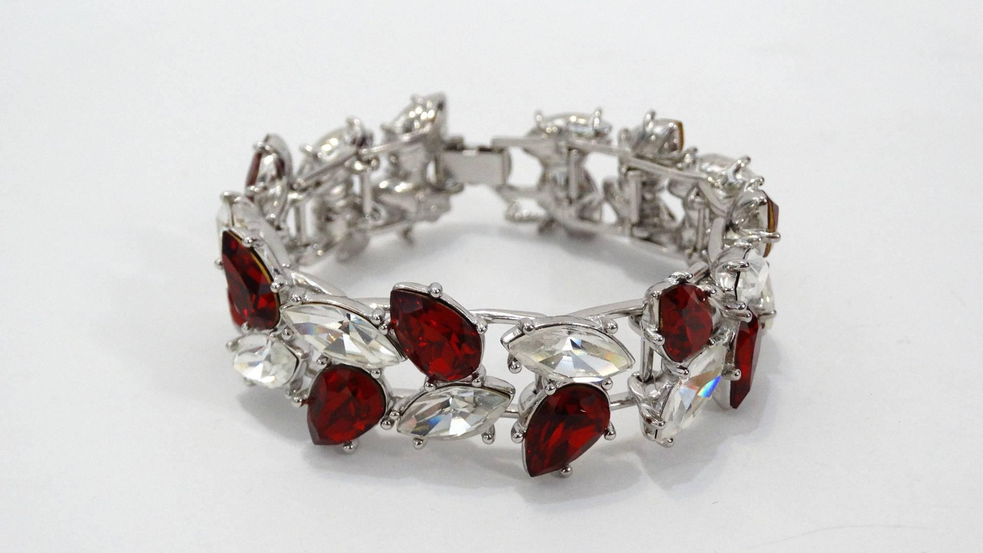 Elevate your evening wear with our amazing 1990s Yves Saint Laurent rhinestone bracelet! Made of a quality silver metal encrusted with leaf-like red and crystal rhinestone gems. Wraps comfortable around the wrist with chain attached to hook closure.