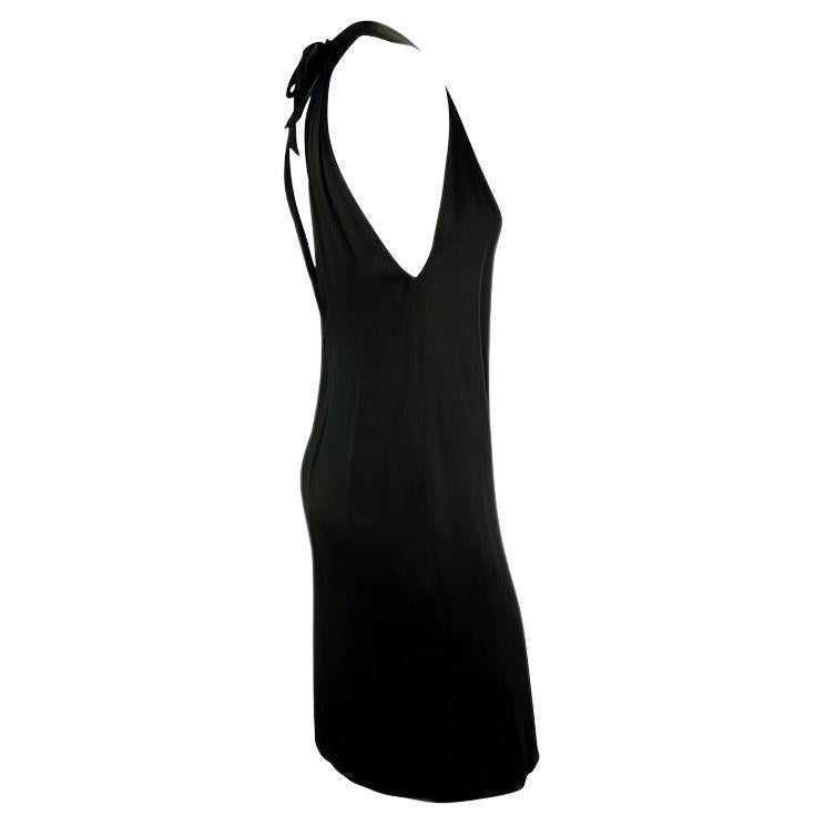 Ich präsentiere ein atemberaubendes Yves Saint Laurent Rive Gauche Kleid aus schwarzem Satin. Dieses kleine Schwarze aus den 1990er Jahren hat einen tiefen V-Ausschnitt, einen tiefen Rückenausschnitt und eine schwarze Schleife auf dem Rücken. Das