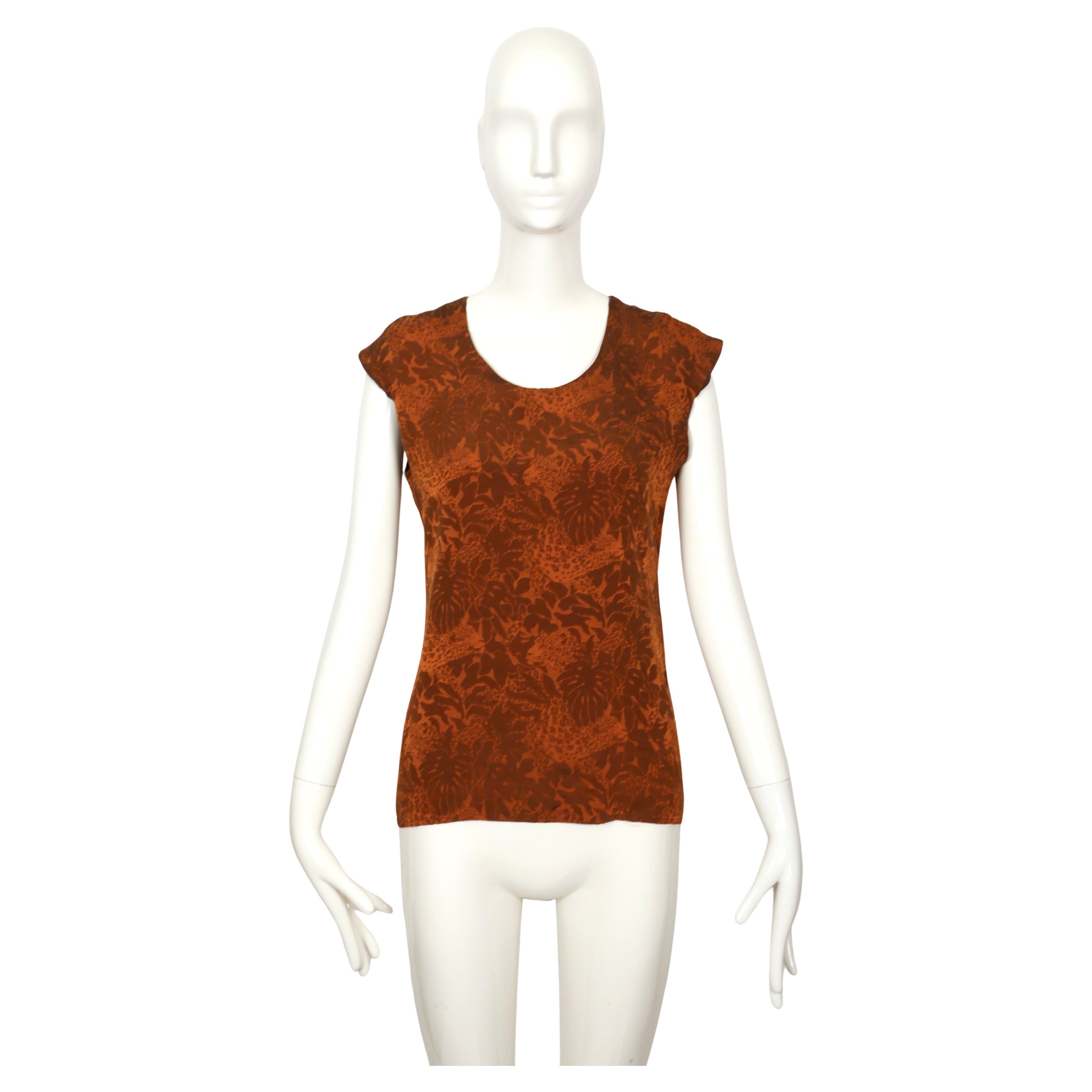 Rust jacquard woven silk top with leopard safari motif designed by Yves Saint Laurent dating to the 1990's. Labeled a French 38. Approximate measurements: shoulder to shoulder 18