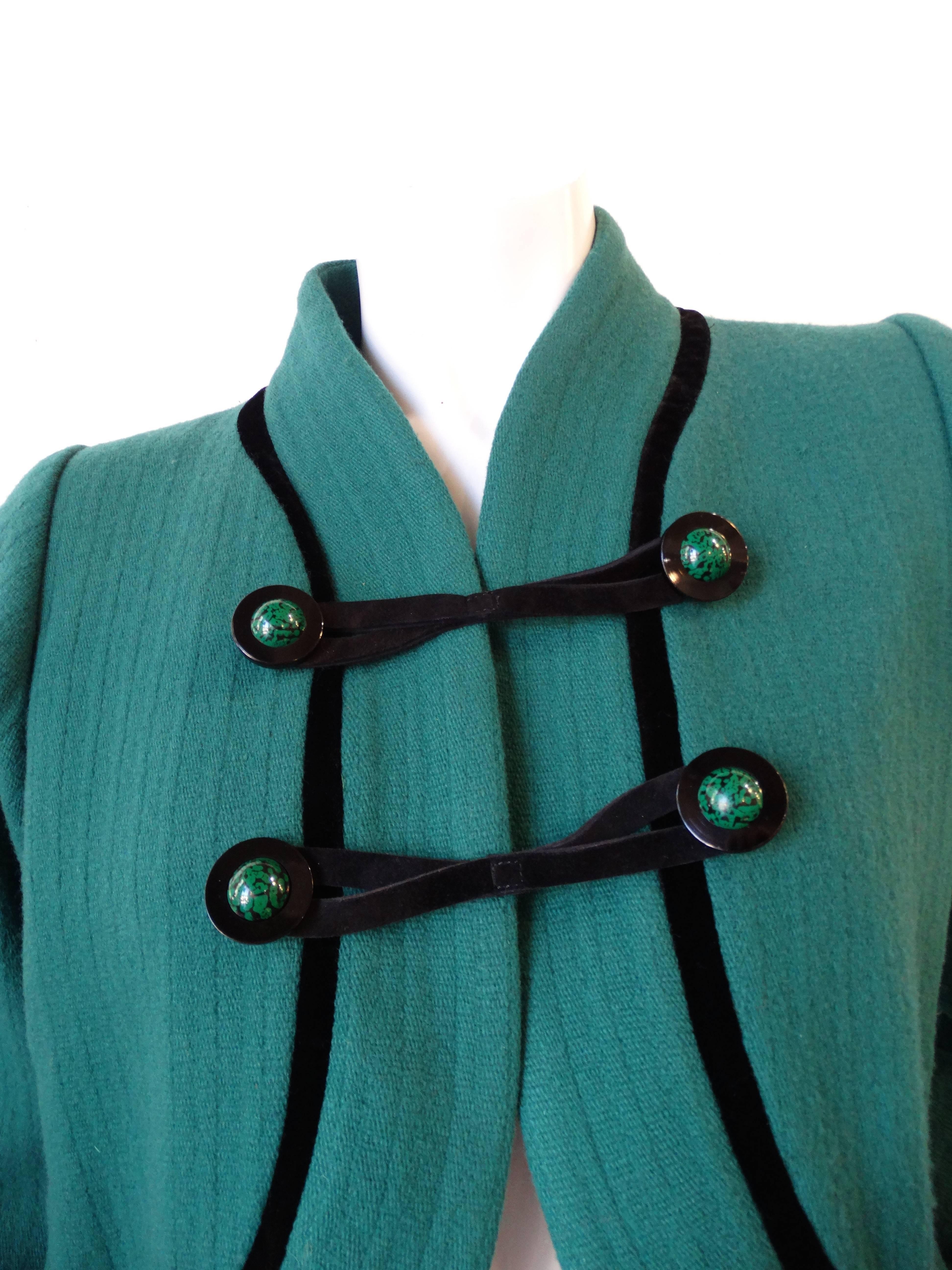 Nobody does outerwear quite like Yves Saint Laurent- and this Rive Gauche piece from the 1990s is no exception! Made of a super soft wool blend fabric in a fabulous jade green color! Trimmed with black piping along the bust and on the elasticized
