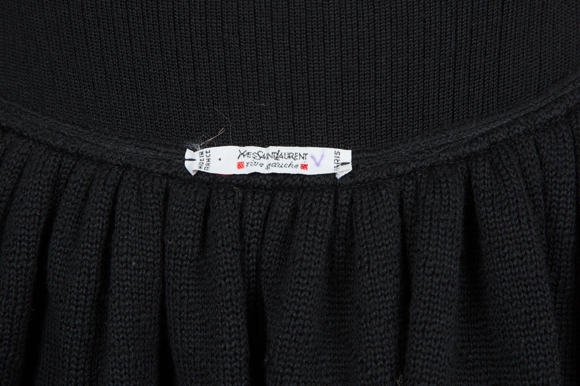 Yves Saint Laurent YSL black wool knitted skirt featuring a high-waisted bell skirt, a bicolor geometric hemline jacquard detail, a side zipper closing.   
Composition: Wool 100%
Circa 1990s
Estimated size 38fr/US6 /UK10
In good vintage condition.