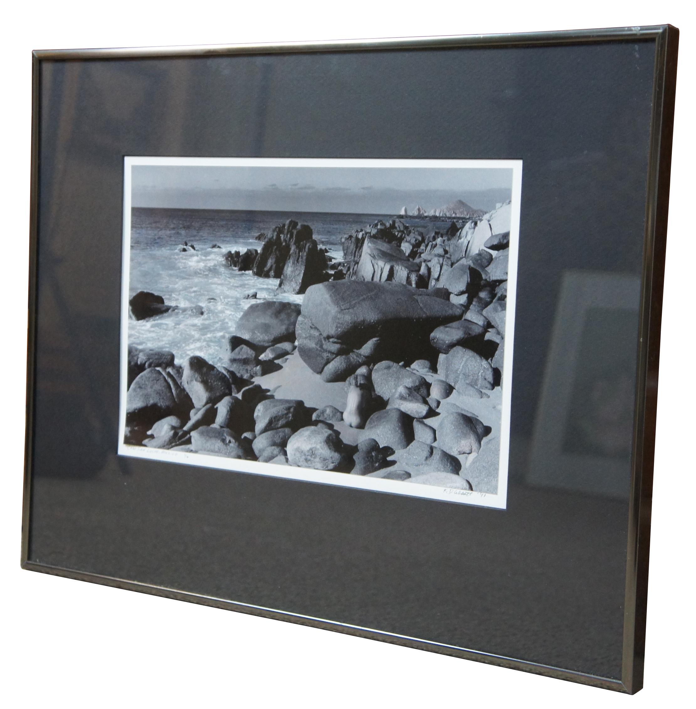 Pencil signed 1991 black and white photograph of a nude figure on a rocky beach in Cabo San Lucas, Mexico by Karen D. Abbott, number 1/2.
 
Sans Frame - 12.25” x 8.25”