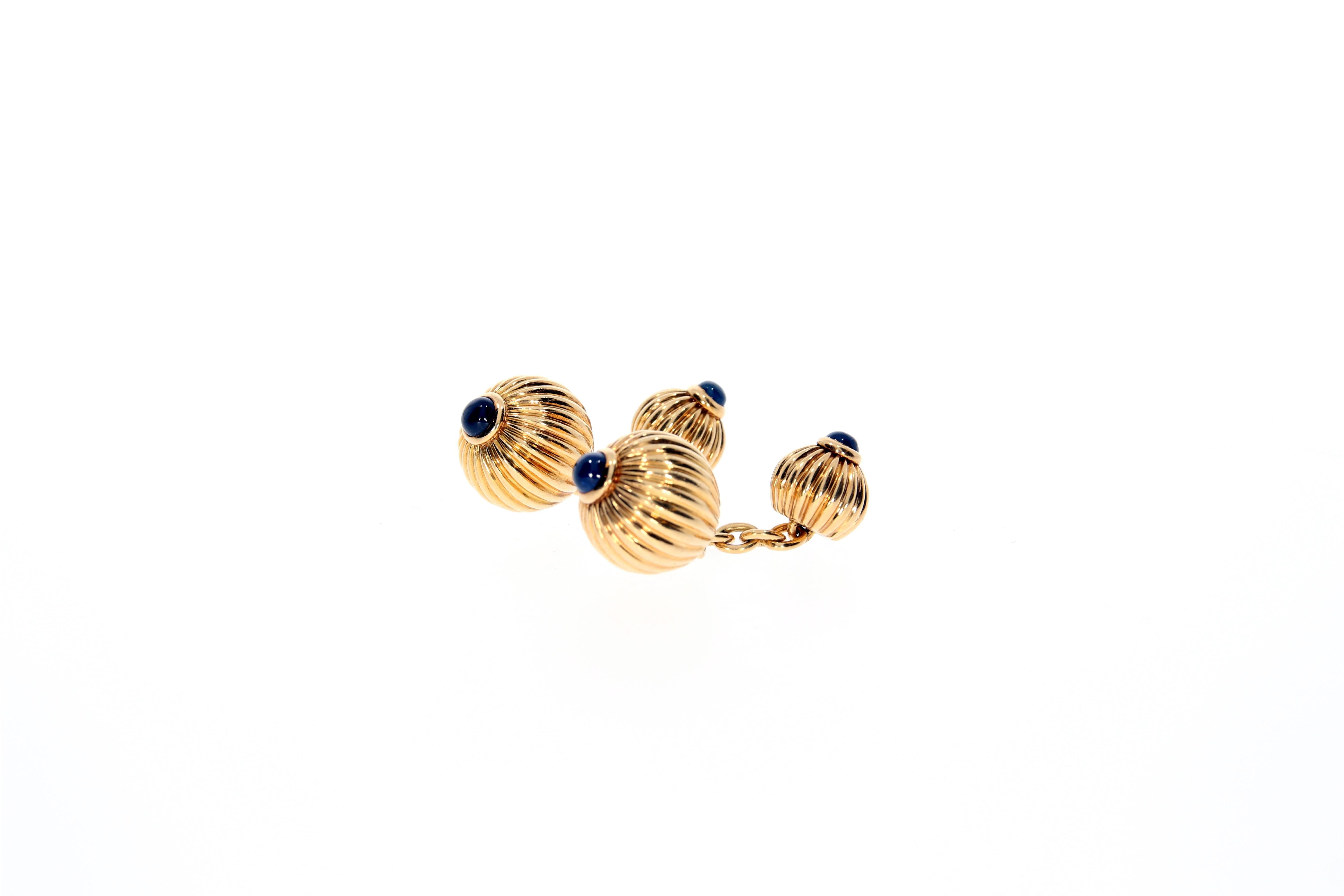 A classic pair of 18 Karat yellow gold melon bead cufflinks, by Cartier. The four golden beads are each topped with a fine blue sapphire cabochon  (in total approx. 1 carat). The jewels are signed and numbered and hallmarked „750“.
