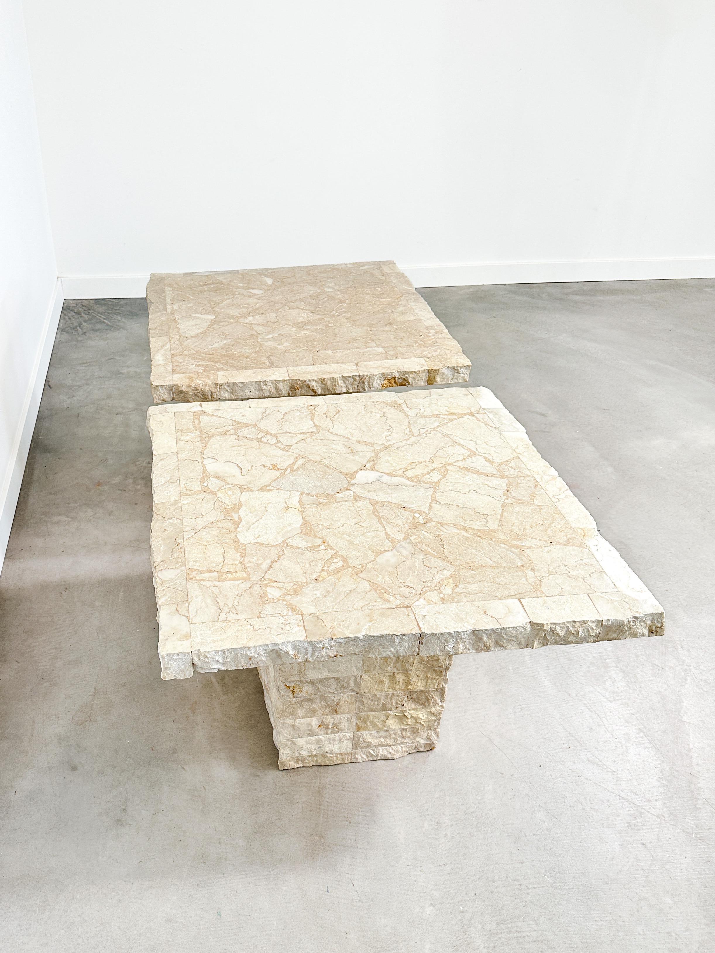 Signed and dated beneath the tops, this rare pair of mosaic stone side tables brings together the raw beauty of natural materials with the precision of postmodern design. Crafted in 1991, each table is a sculptural blend of marble and travertine,