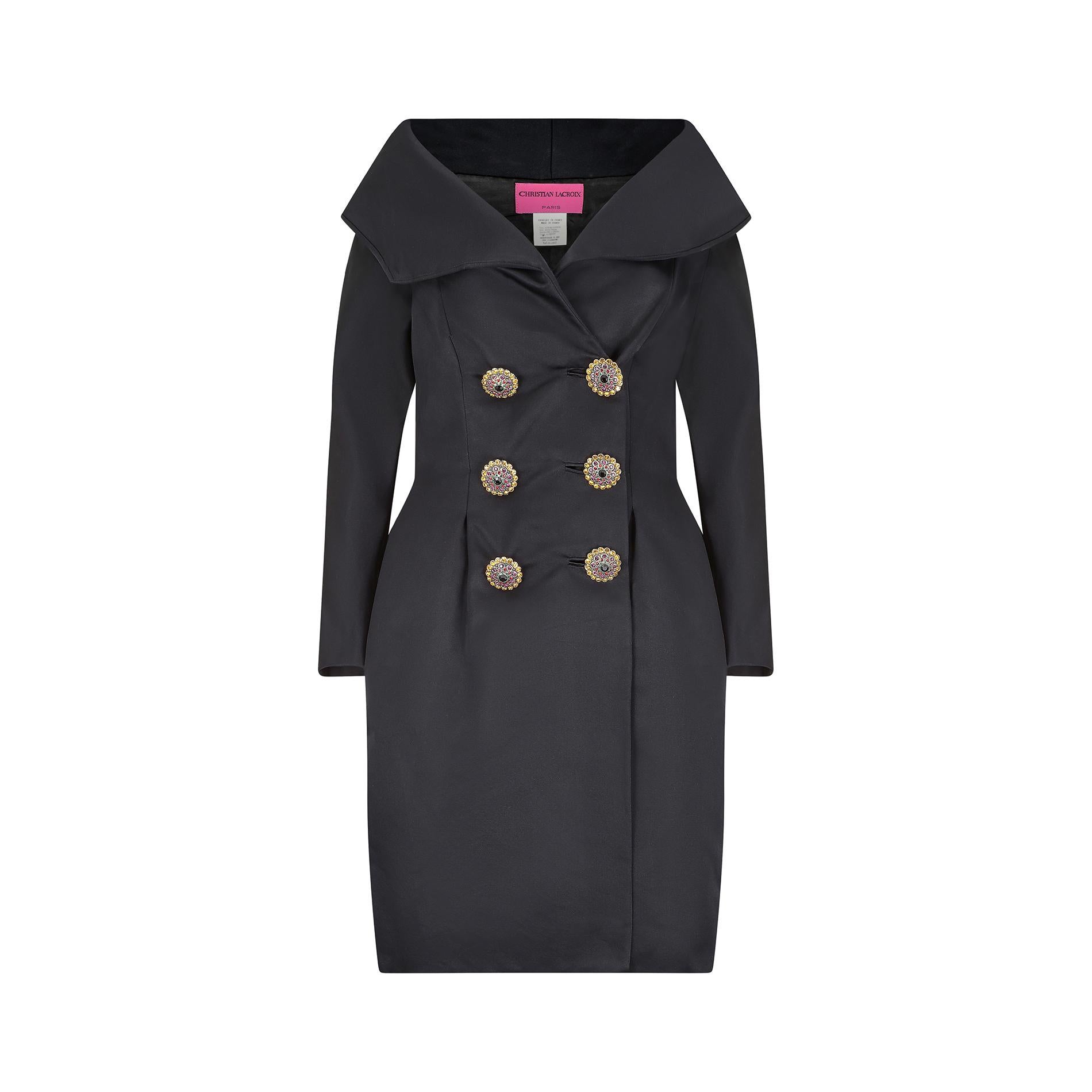 Superbe robe de smoking en soie noire de Christian Lacroix, ornée de gros boutons en cristal. Cette robe ajustée présente un col très large, presque bardot, qui rappelle les tenues de soirée chics des années 1950. Le devant est coupé dans un style