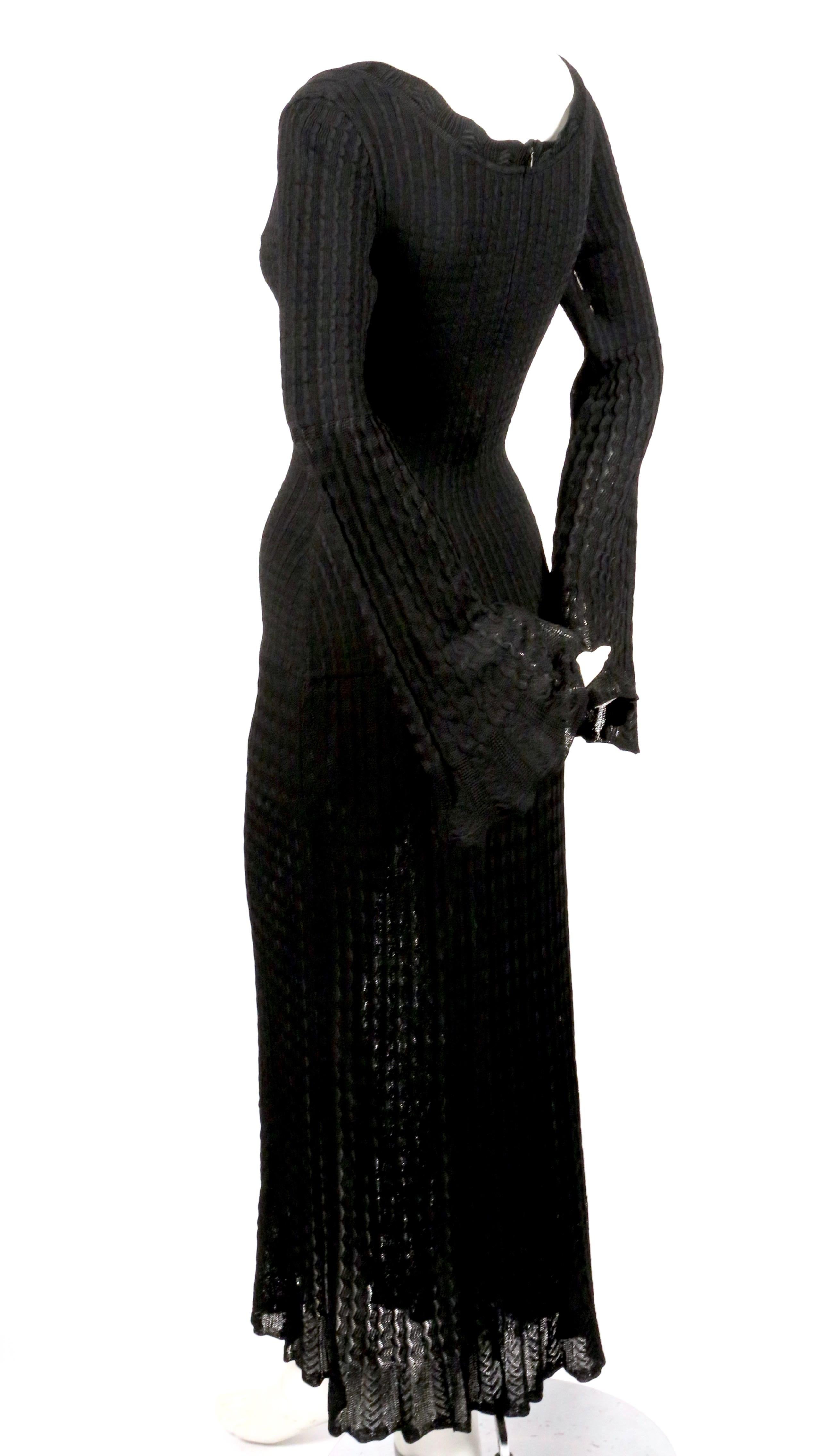 Jet-black, open knit dress with flounce hemline and bell sleeves from Azzedine Alaia dating to 1992. Size is unmarked however this best fits a size 'S'. Approximate measurements (unstretched): shoulder 15