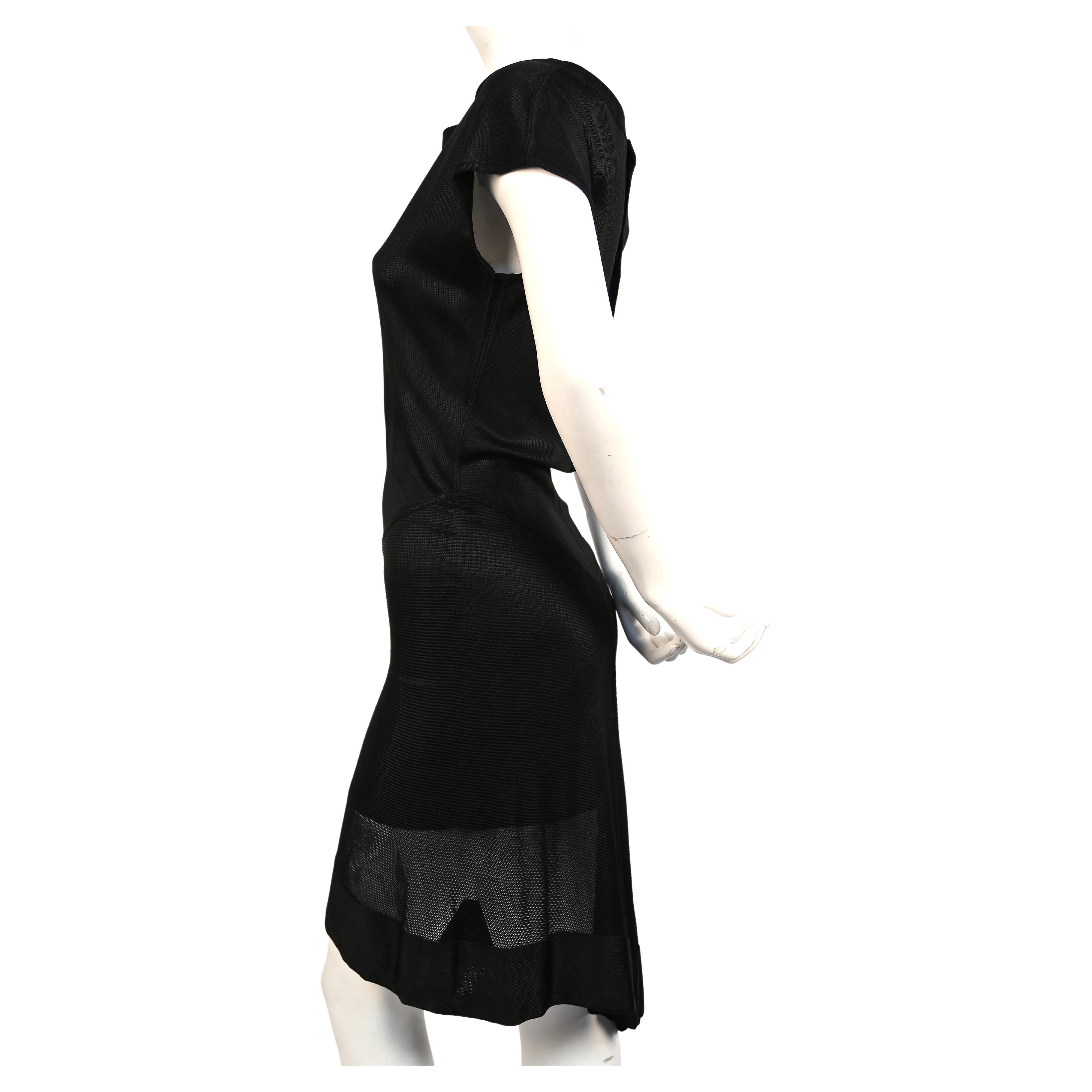 Jet black viscose dress with sheer asymmetrical hemline from Azzedine Alaia dating to spring of 1992. Labeled a size 'M', although this will also fit a size S. Approximate measurements: 33-34