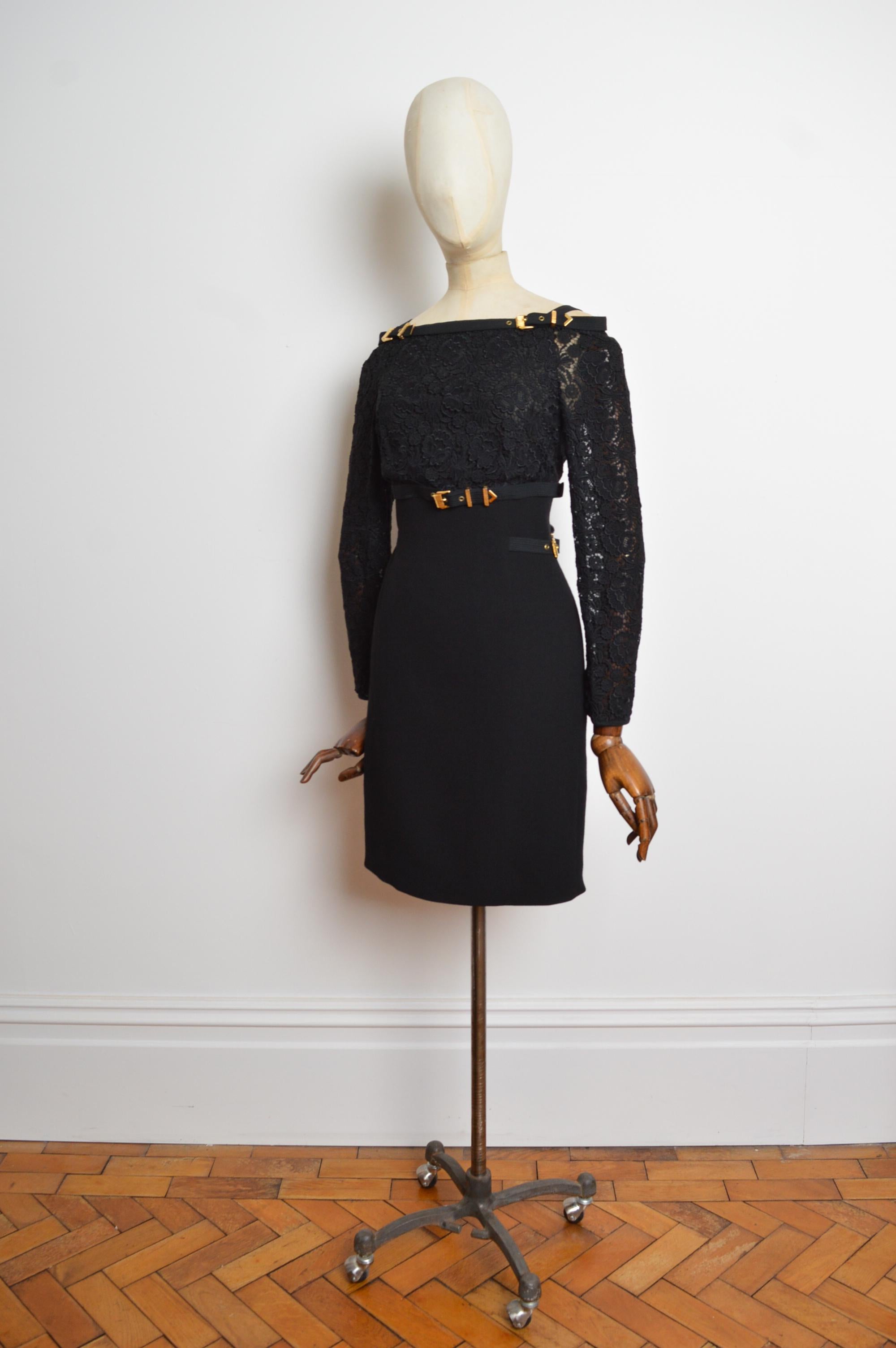 Fabelhaftes Gianni Versace Couture Kleid aus dem Jahr 1992, gefertigt aus schwarzer Spitze mit goldenen Schnallenverzierungen. Das Kleid hat eine schulterfreie Silhouette mit figurbetonter Form und einen verdeckten Reißverschluss am Rücken.