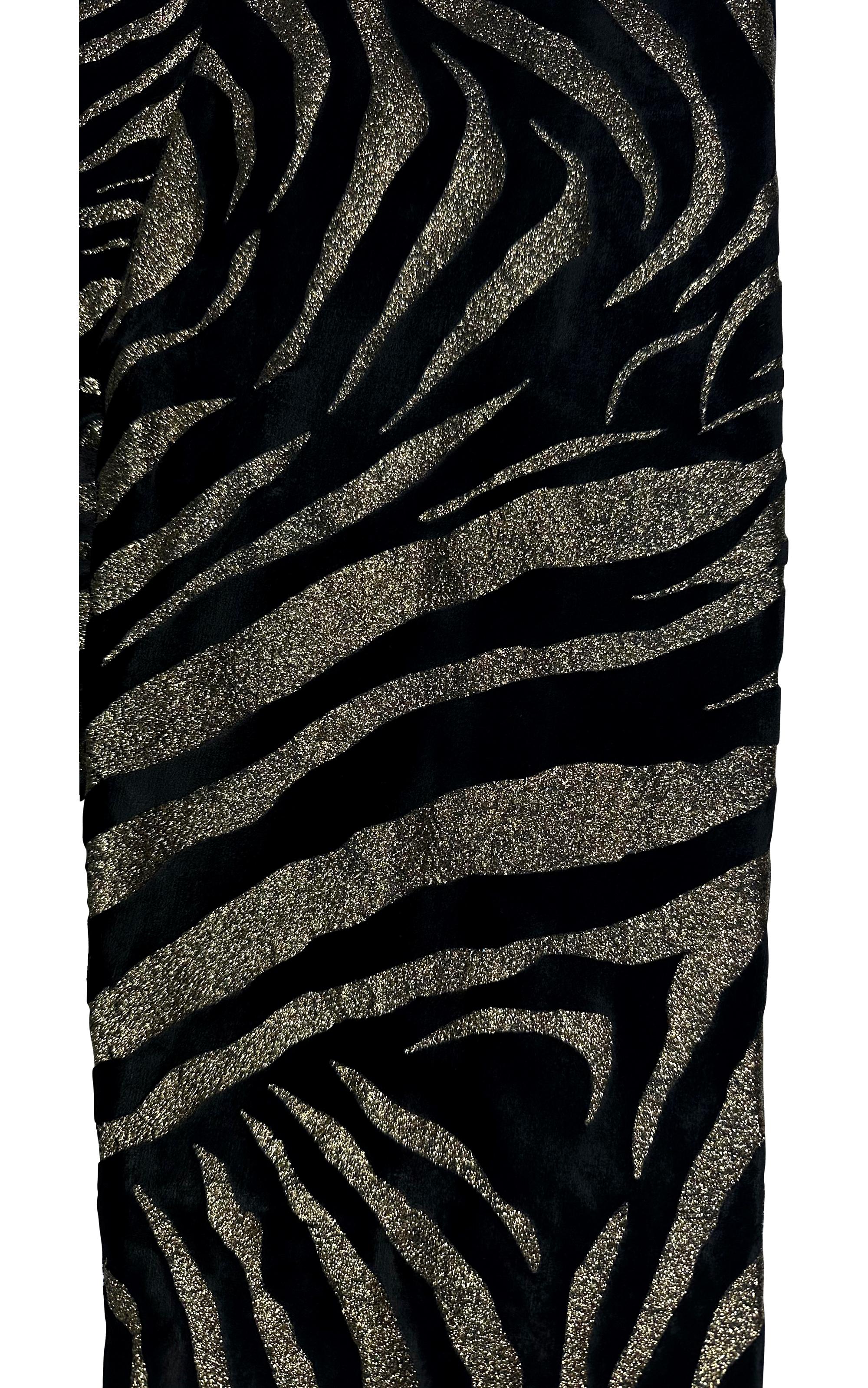 These striking Gianni Versace leggings from 1992 feature a bold black velvet fabric with an eye-catching gold glitter animal pattern. The stretch fit and high-waisted silhouette embody the opulent and daring style that defined Versace in the early