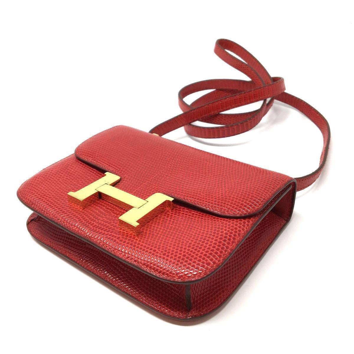 Hermes Paris Rare Mini Costance 20 cm Lizard Rouge Garance. The micro Constance is the smallest version of the impeccable craftsmanship of this line. It has no inside pockets and is lined in red leather. The hardware is gold tone and the shoulder