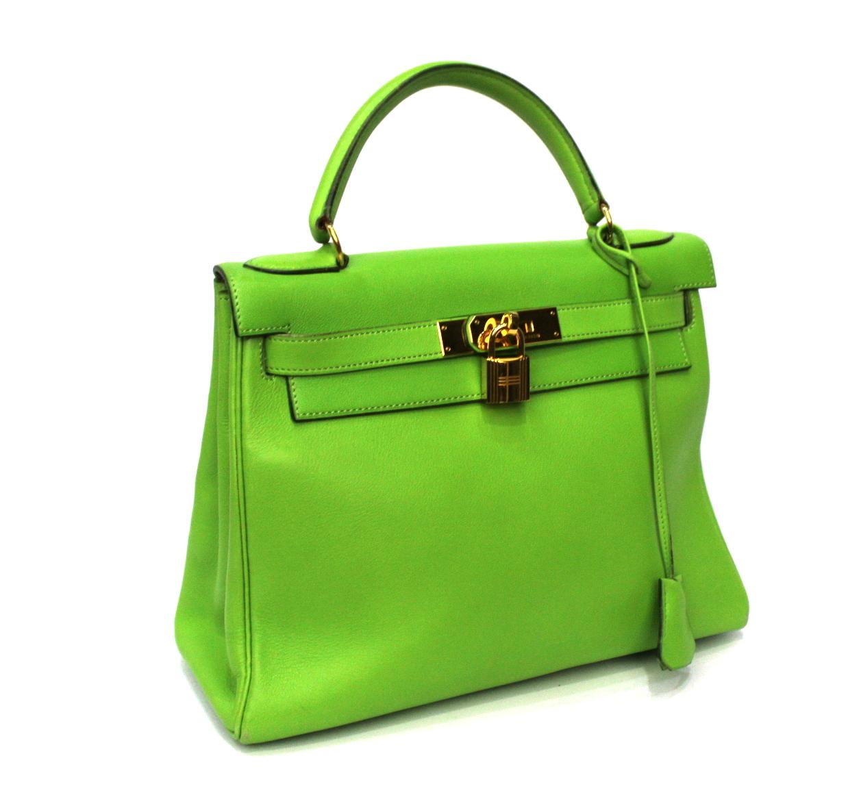 Hermès designer bag model Kelly 28 cm made of apple green smooth leather with golden hardware. Equipped with top handle and removable leather shoulder strap. The bag is in good condition, slightly worn corners. The live color is even more beautiful,