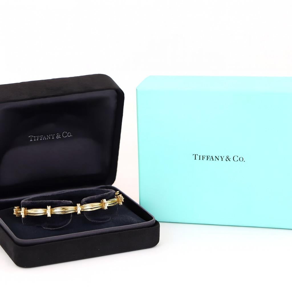 1992 Pulsera vintage Tiffany & Co. de oro amarillo de 18 quilates con la firma del diamante

Esta emblemática pulsera Tiffany & Co. de 1992 exhibe una elegancia atemporal en oro amarillo de 18 quilates. La pieza presenta 30 diamantes redondos de