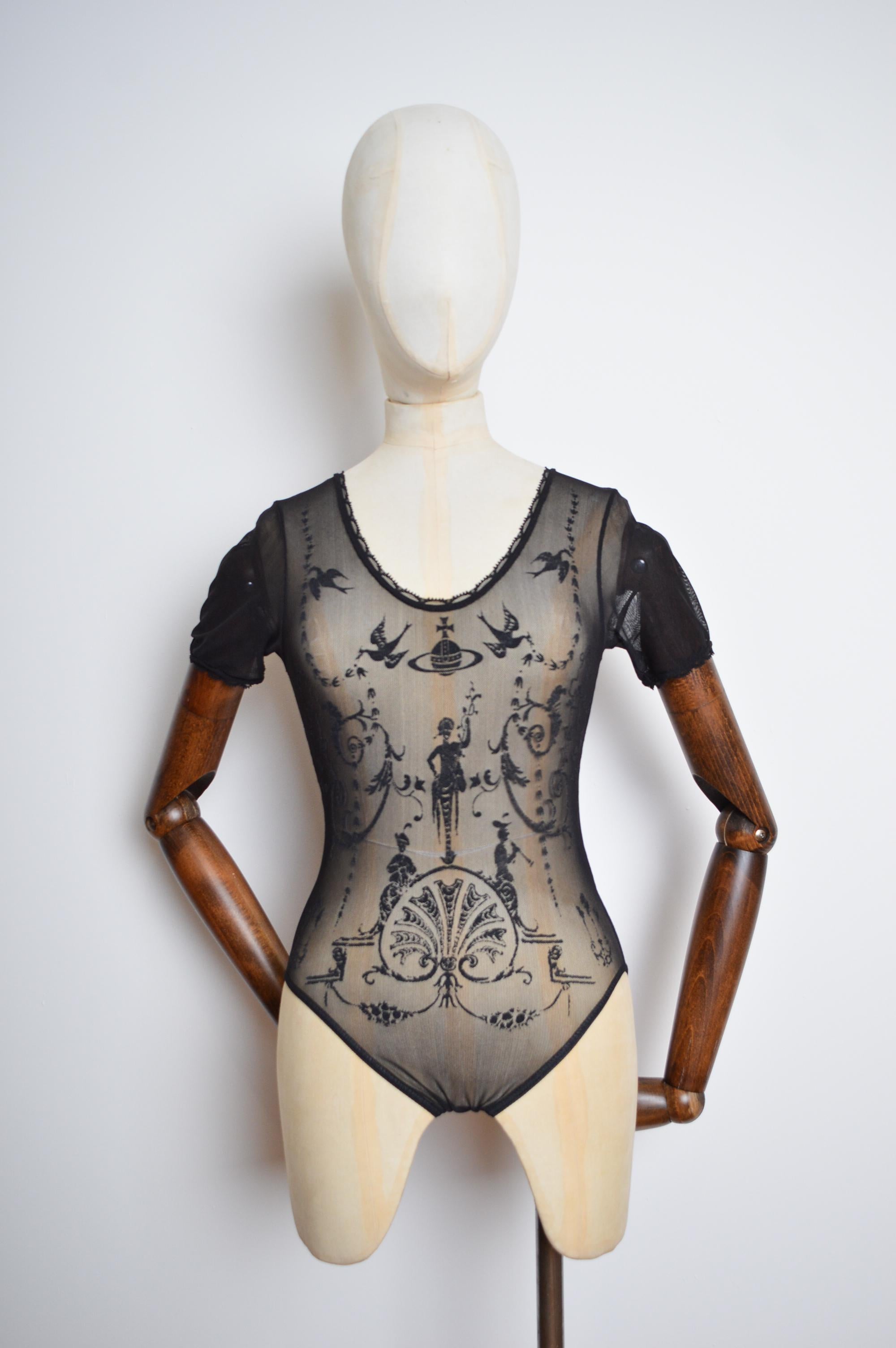 Der ikonische Vivienne Westwood x Sock Shop Bodysuit aus dehnbarem Mesh von 1992.   

Größe XS-S, die Schaufensterpuppe hier ist eine UK 6 und der Body passt perfekt!   

Merkmale:  
Kurze Ärmel  
Rundhalsausschnitt
Gemusterte Front    

Großartiger
