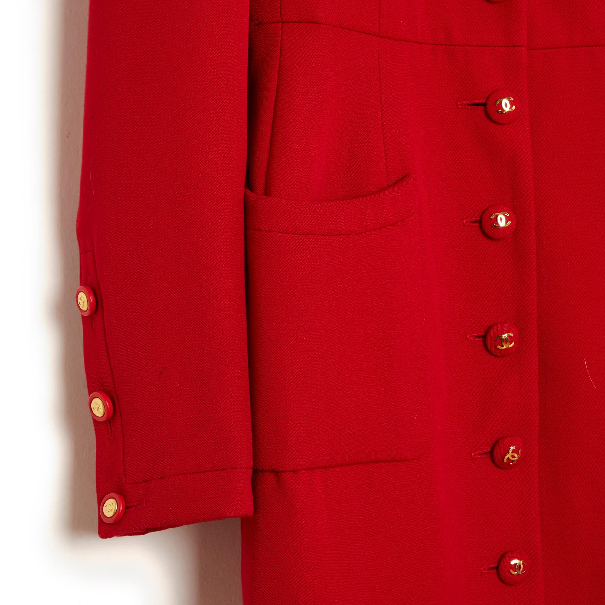 Chanel mid-length Fall Winter 1992 collection dress coat in plain red wool crepe (and probably silk), notched collar closed with 9 red resin buttons decorated with a CC logo, 4 patch pockets on the chest and on the hips, long sleeves closed with 3