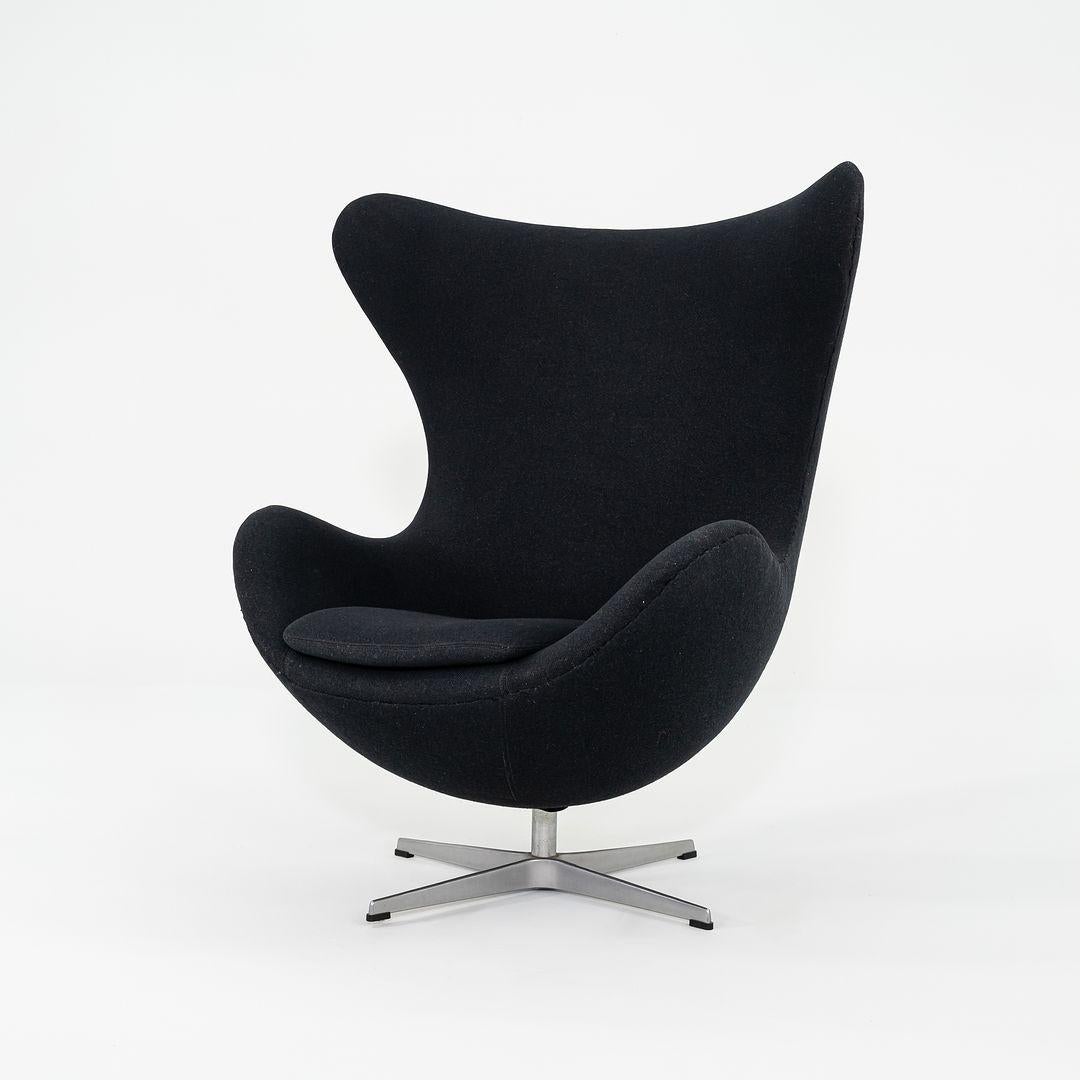 Il s'agit d'une chaise et d'un pouf Egg originaux, initialement conçus par Arne Jacobsen pour Fritz Hansen en 1959. Ce coffret date de 1993 et a été produit au Danemark. Il est doté d'une base pivotante à quatre points en aluminium et a conservé son