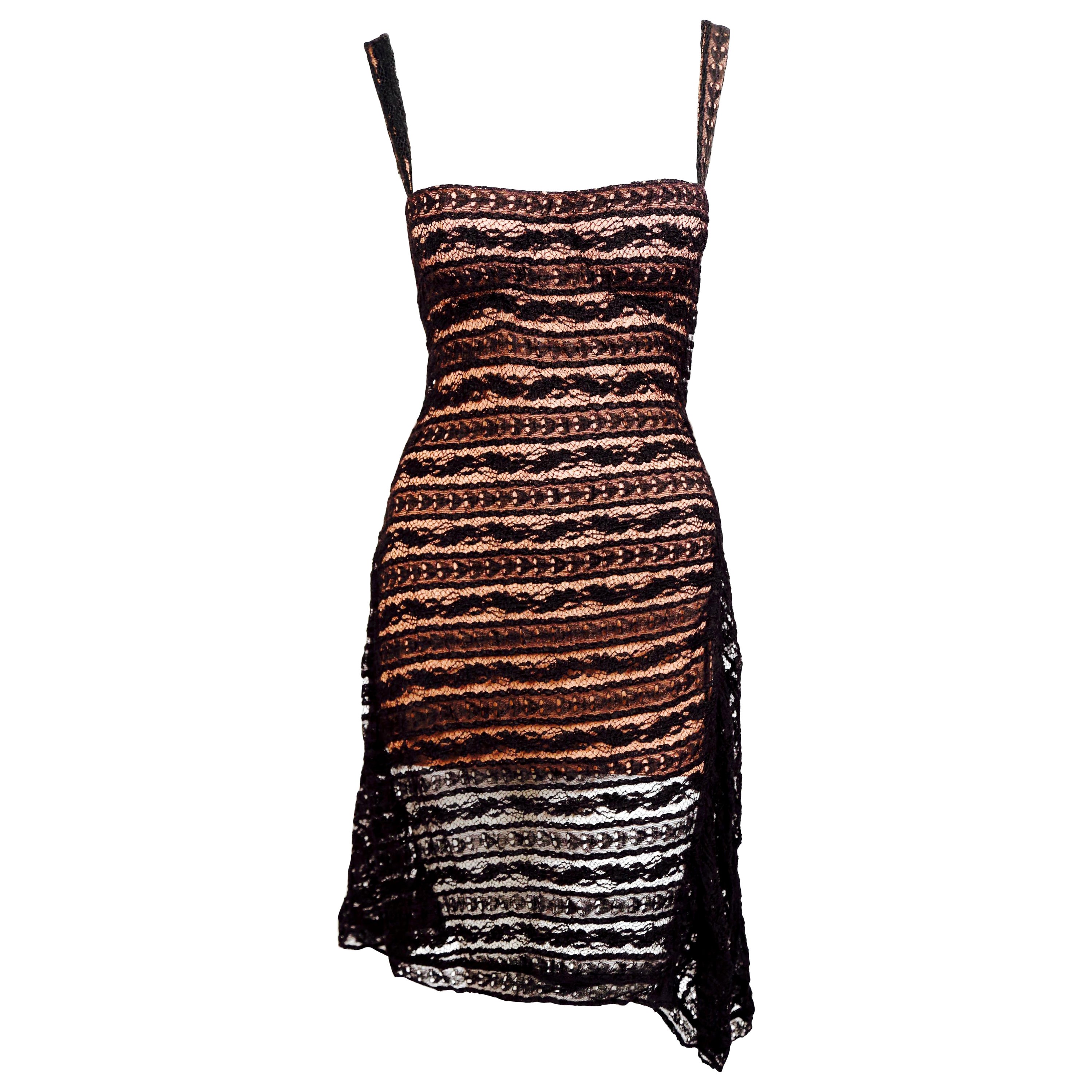 Very rare, black lace dress with blush pink lining and molded busier designed by Azzedine Alaia dating to spring of 1993. This is a very collectible and highly documented piece. Lace overlay is cut asymmetrically and falls elegantly over the blush