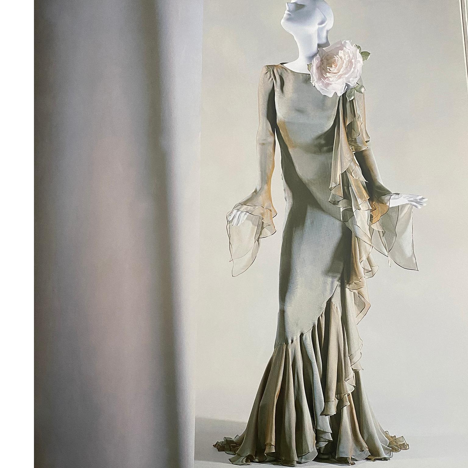 Nous adorons cette sensationnelle robe Bill Blass vintage 1993 en mousseline de soie fine avec une doublure chair/pêche et une superposition de mousseline vert sauge. L'effet est celui d'une irisation de bronze et de vert. Les jolis volants tombent