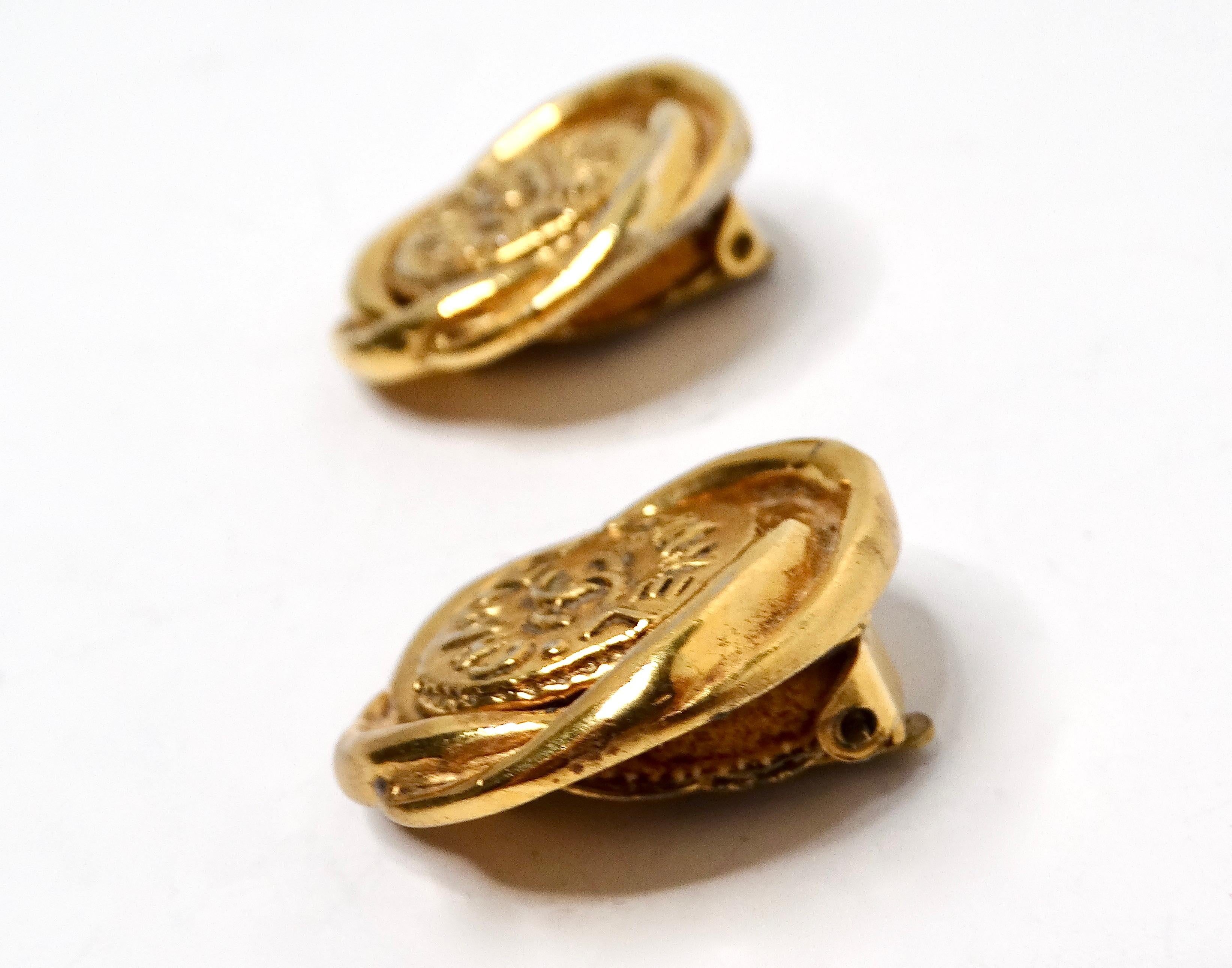 Concediti un'eleganza senza tempo con questi splendidi orecchini a clip in oro Chanel 1993, che ricordano gli affascinanti bottoncini Chanel. Ornati dall'iconico logo CC, questi orecchini trasudano raffinatezza e classe. Perfettamente versatili,