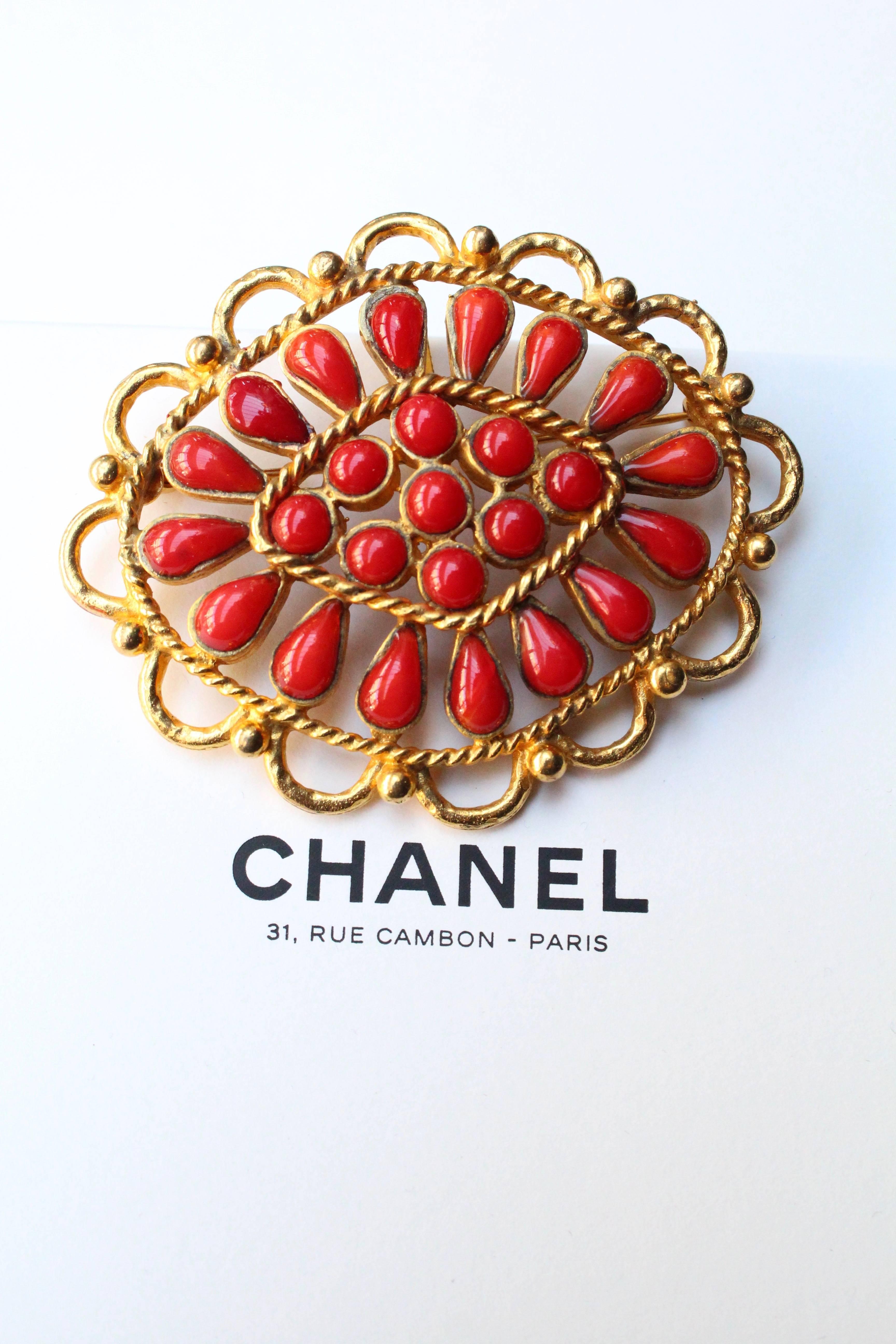 CHANEL (Made in France) Rare example of a gorgeous oval brooch composed of ruby red glass paste cabochons in the shape of tear drops set in gilded metal. It can also be worn as a pendant, thanks to a back hook.

Beautiful work from Maison Gripoix