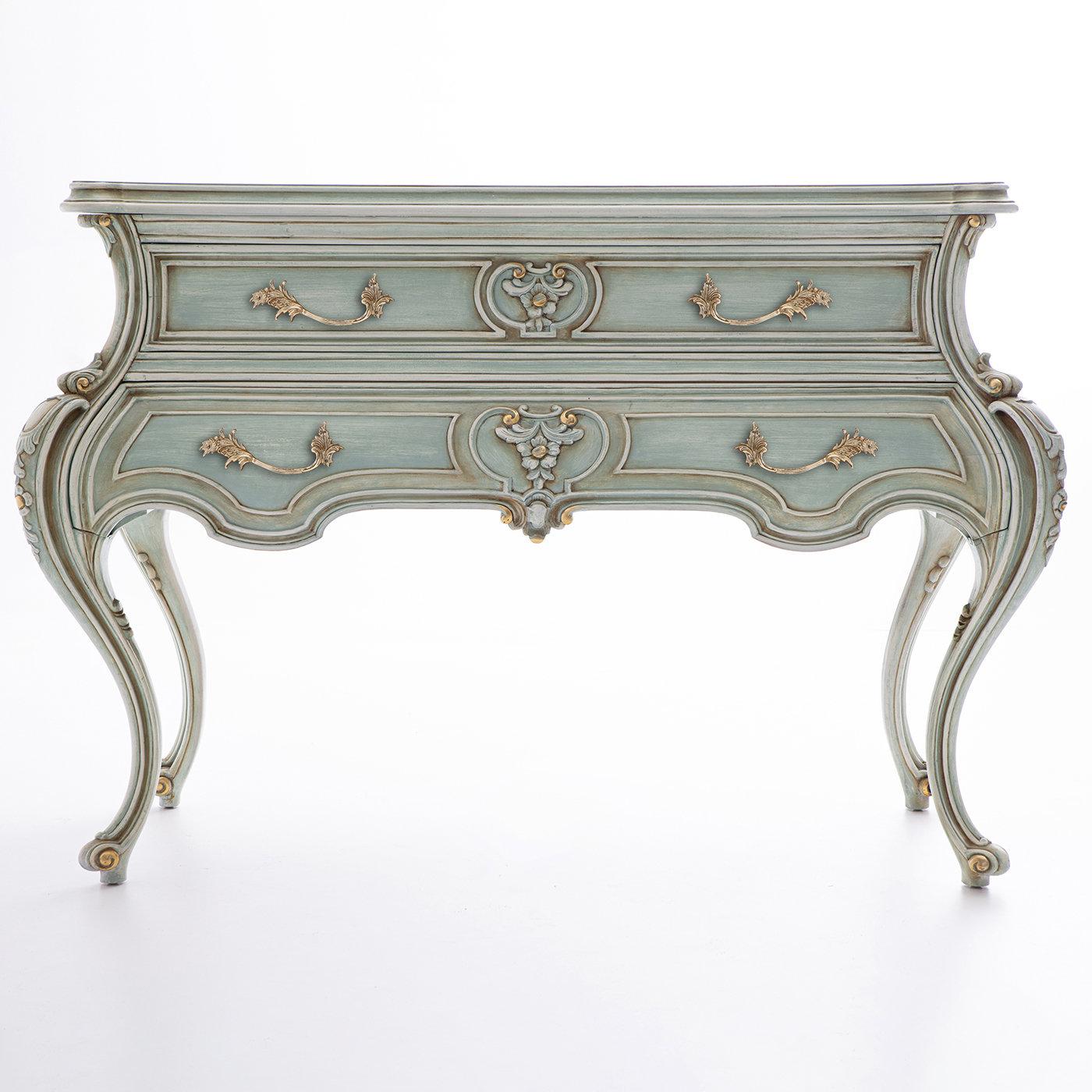 The graceful, sinuous profile of this classic dresser in solid wood contributes to its unparalleled sophistication, emphasized by luminous golden details. Superb carvings executed by hand embellish the cabriole-style legs and the two drawers