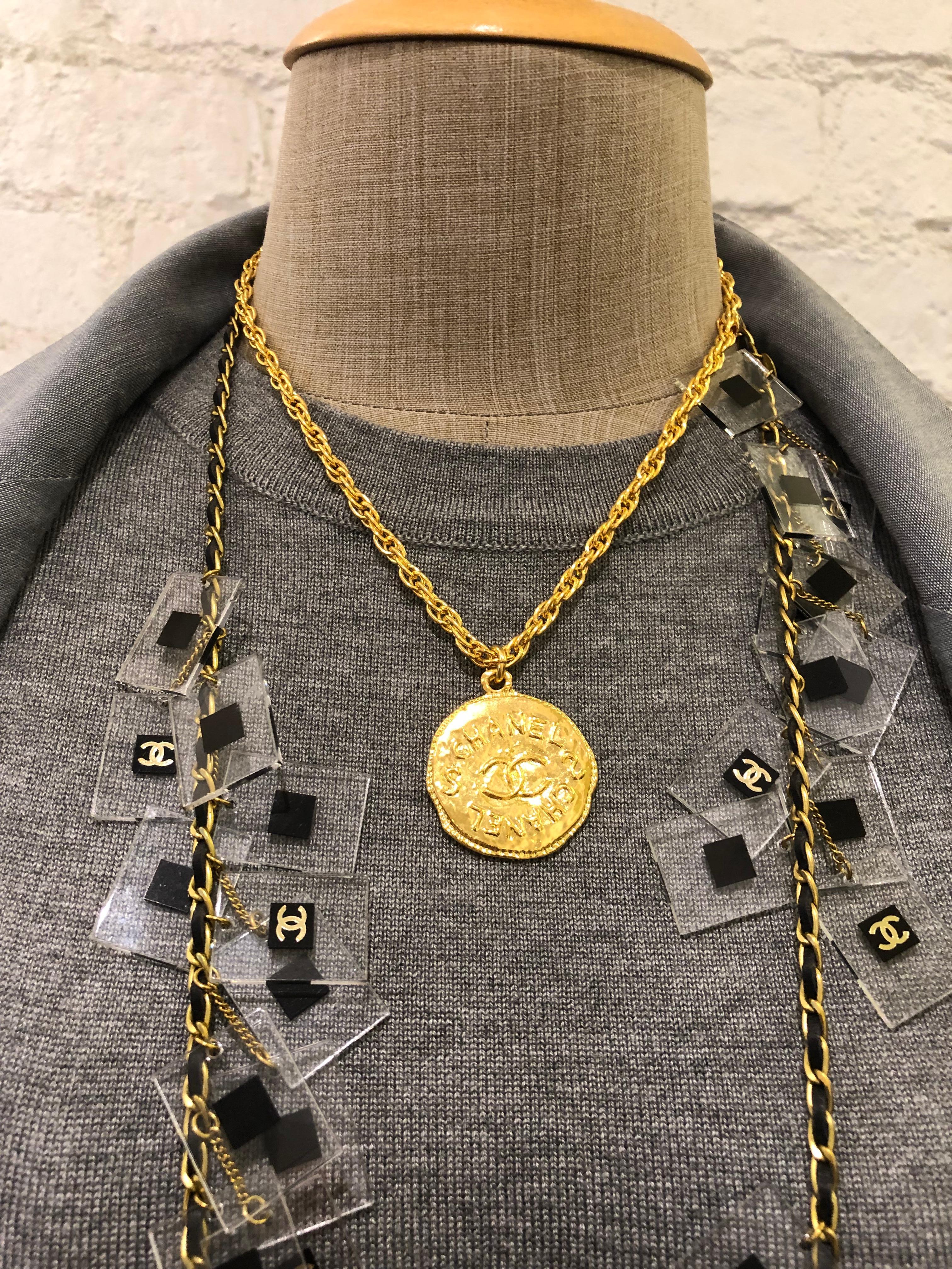Ce collier court vintage CHANEL est composé d'une chaîne dorée ornée d'une breloque en forme de pièce de monnaie de style byzantin. Fermeture par anneau à ressort. Estampillé 93P CHANEL fabriqué en France. Mesure environ 44 cm Diamètre de la