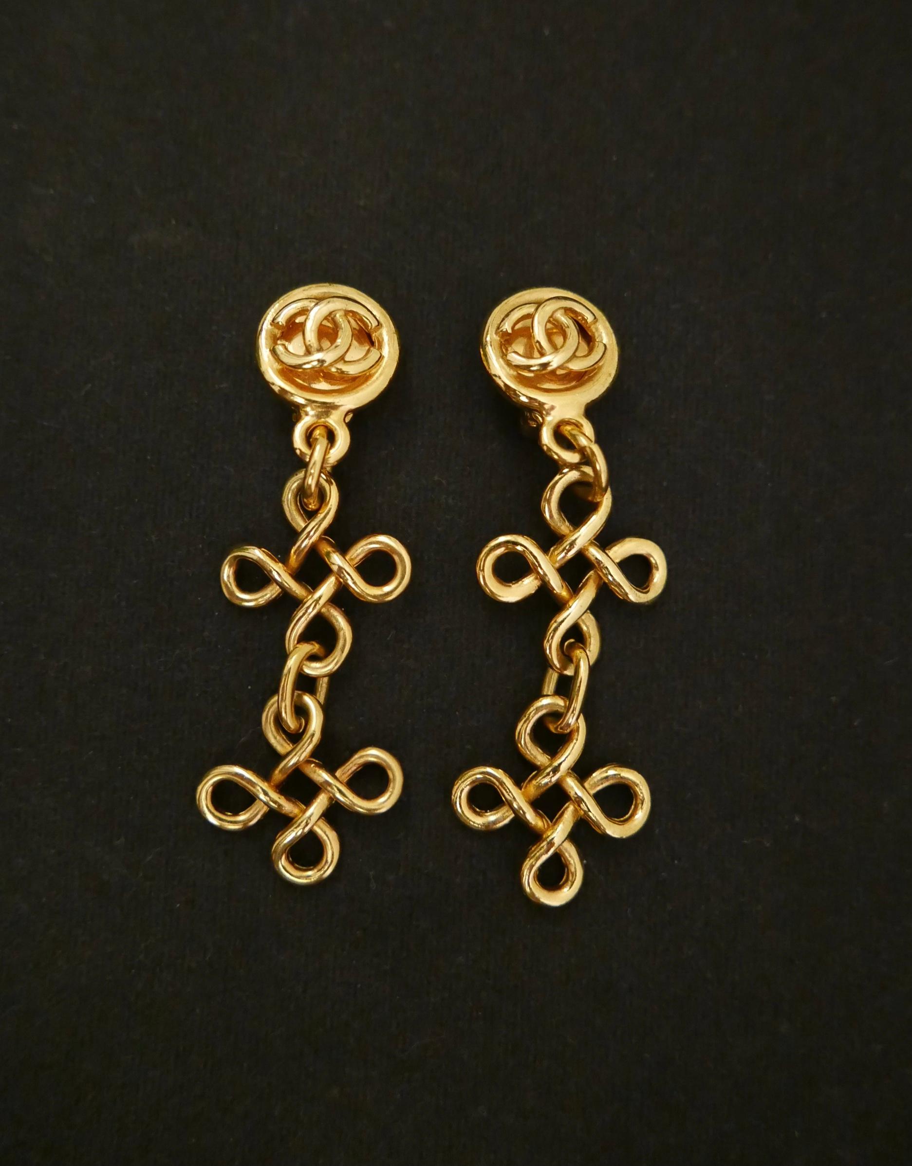 Vintage CHANEL gold toned dangle ear-clips featuring a CC logo and two tiers of clover motifs. An absolute stunning piece to add to your vintage collection. Stamped 93P, made in France. Measures approximately 2.4 x 7.6 cm. Clip on style. Come with