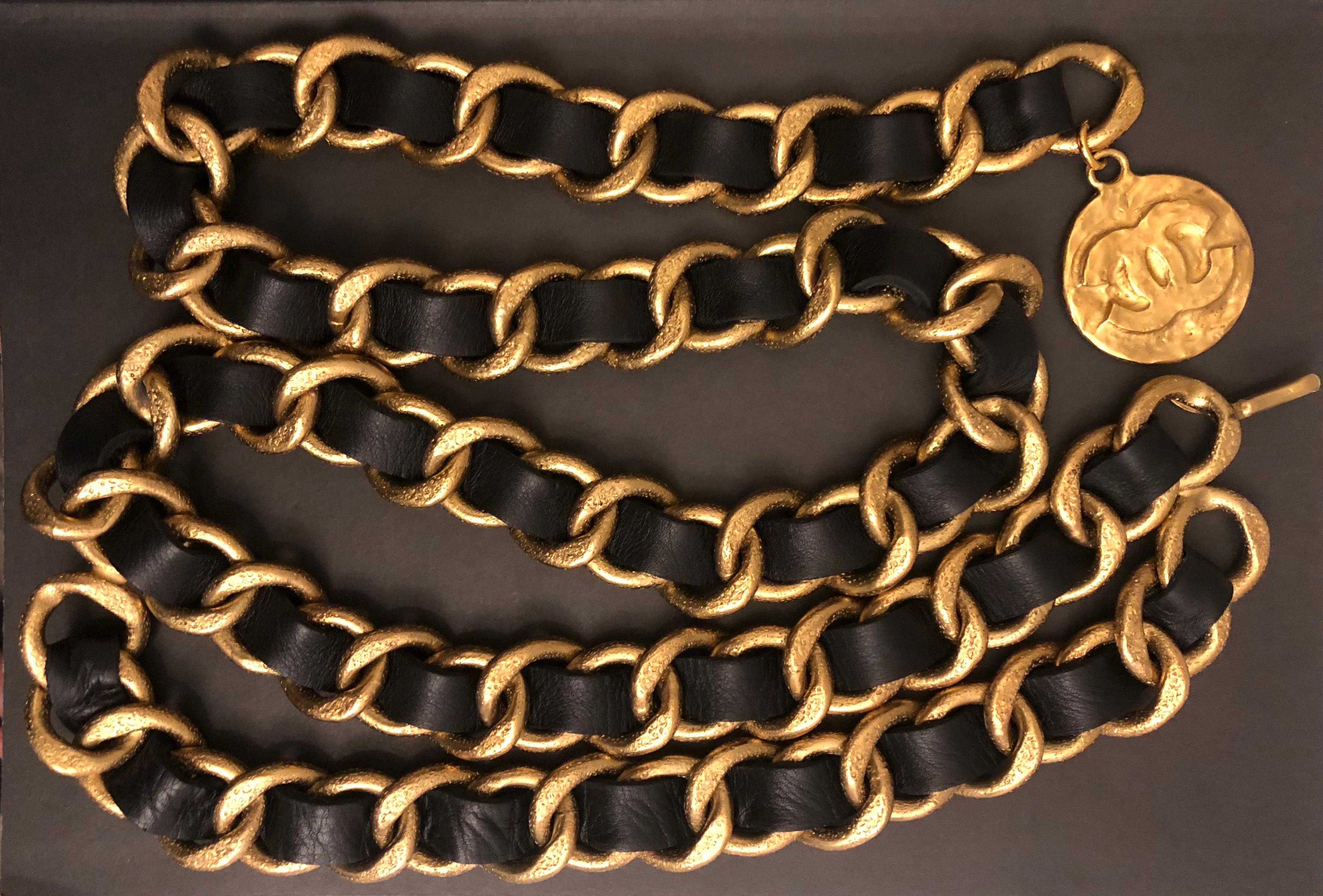 This vintage Chanel chain belt is crafted of massive gold toned textured chain interlaced with black leather featuring double chain draping and a Byzantine styled CC medallion coin charm. Seen on 1993 SS Runway. Stamped CHANEL 93A made in France.