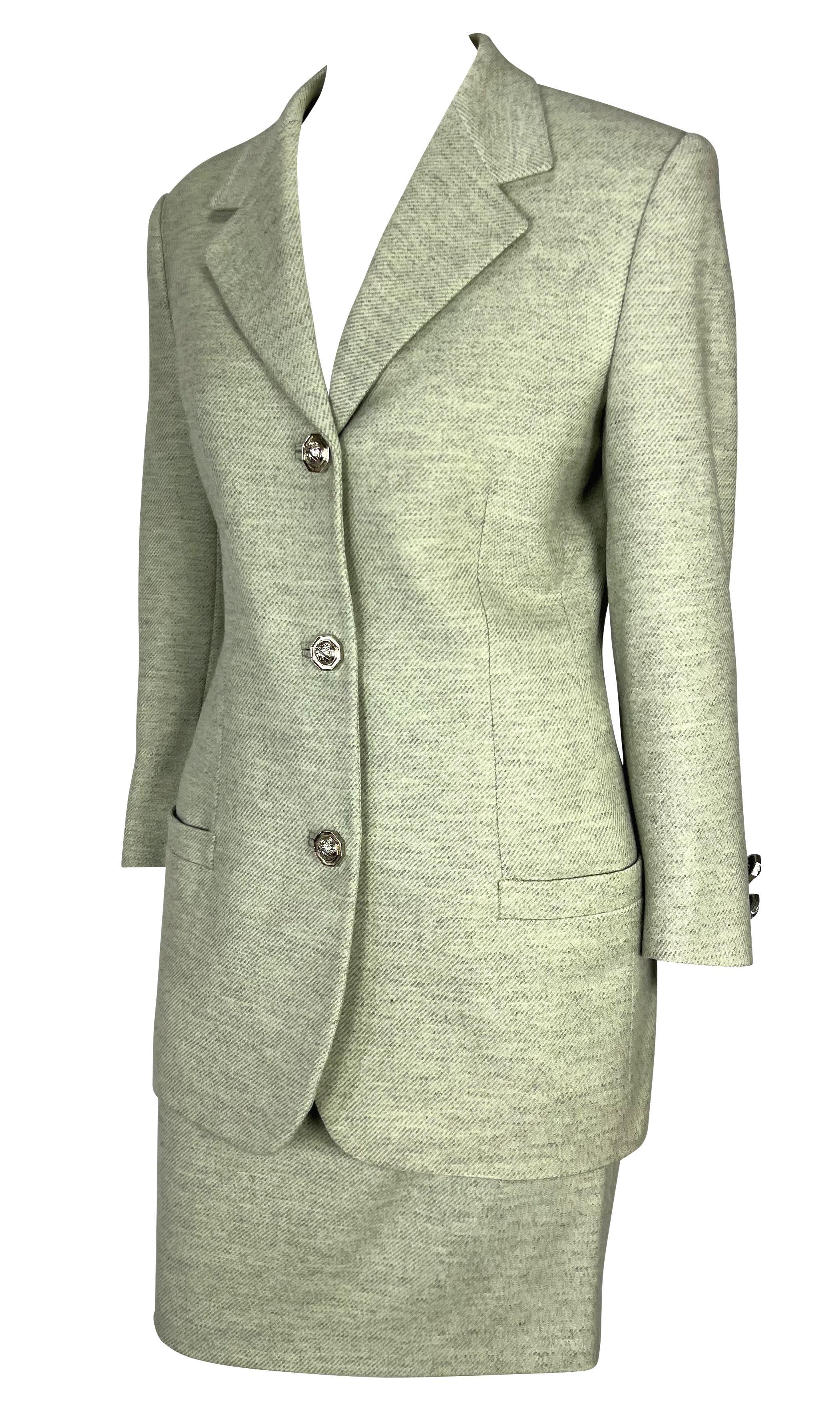 Ti presentiamo un design Gianni Versace, un bellissimo tailleur con gonna in lana Gianni Versace Couture color menta e grigio. Questo favoloso tailleur con gonna della collezione Primavera/Estate 1994 è composto da un blazer standard e da una gonna