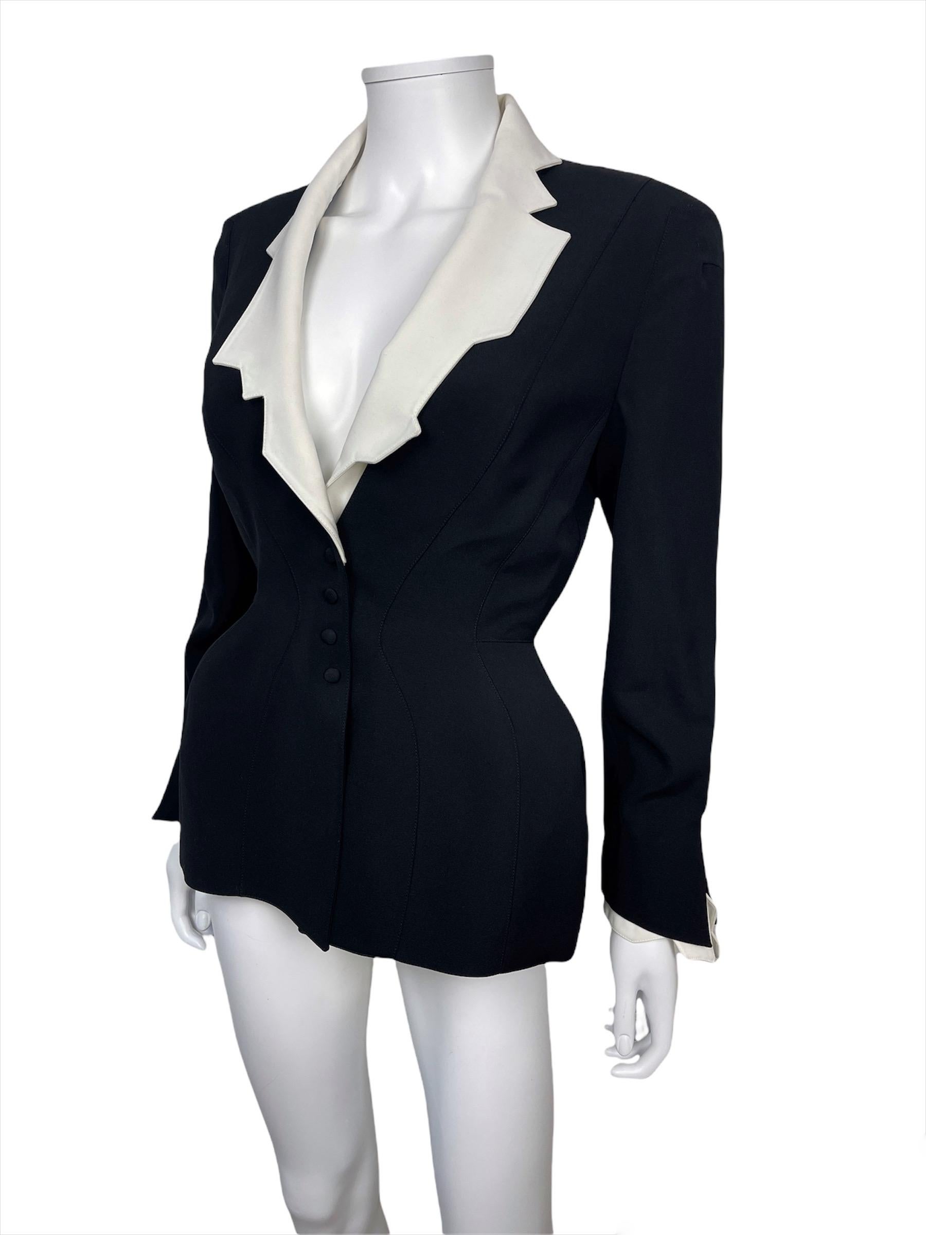 THIERRY MUGLER, fabriqué en France, printemps-été 1994. 

Veste cintrée iconique avec un col blanc sculptural. Entièrement doublé. Tissu en laine peignée, boutons-pression. 
L'étiquette indique une taille de 38FR mais la taille est assez petite,