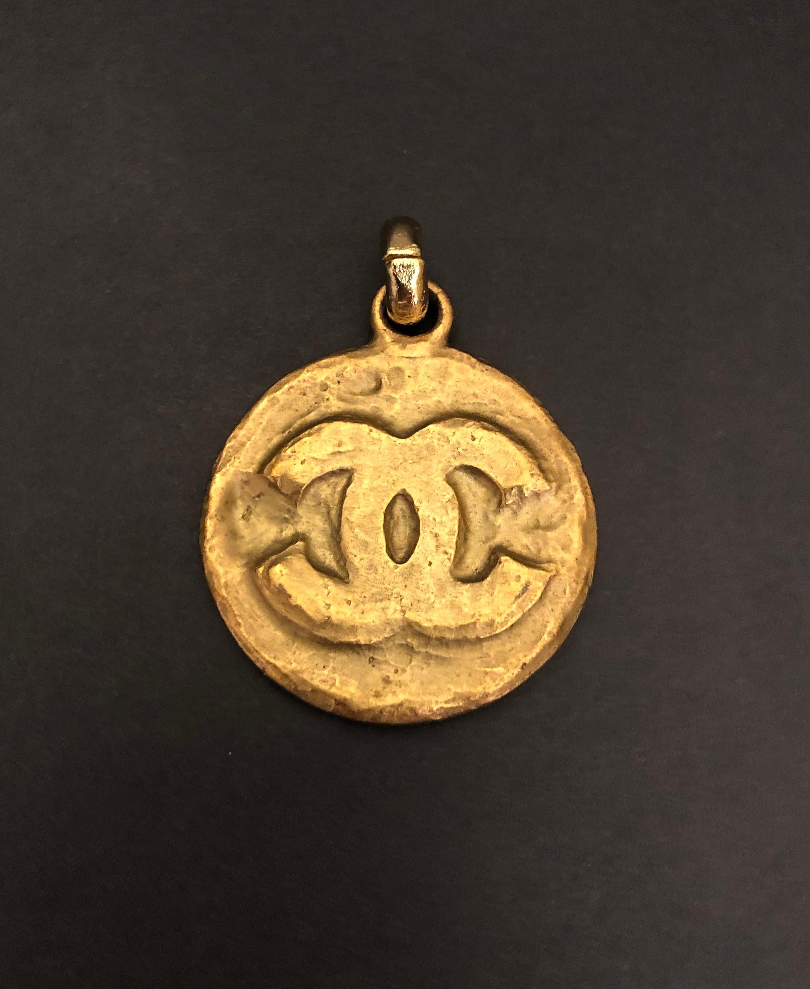 This vintage CHANEL gold toned CC medallion charm that was part of a vintage CHANEL keychain is crafted of gold toned metal in Byzantine style. Measures approximately 4 x 4.7 cm. Stamped Chanel 94P made in France. 

NOTE: The necklace in the picture