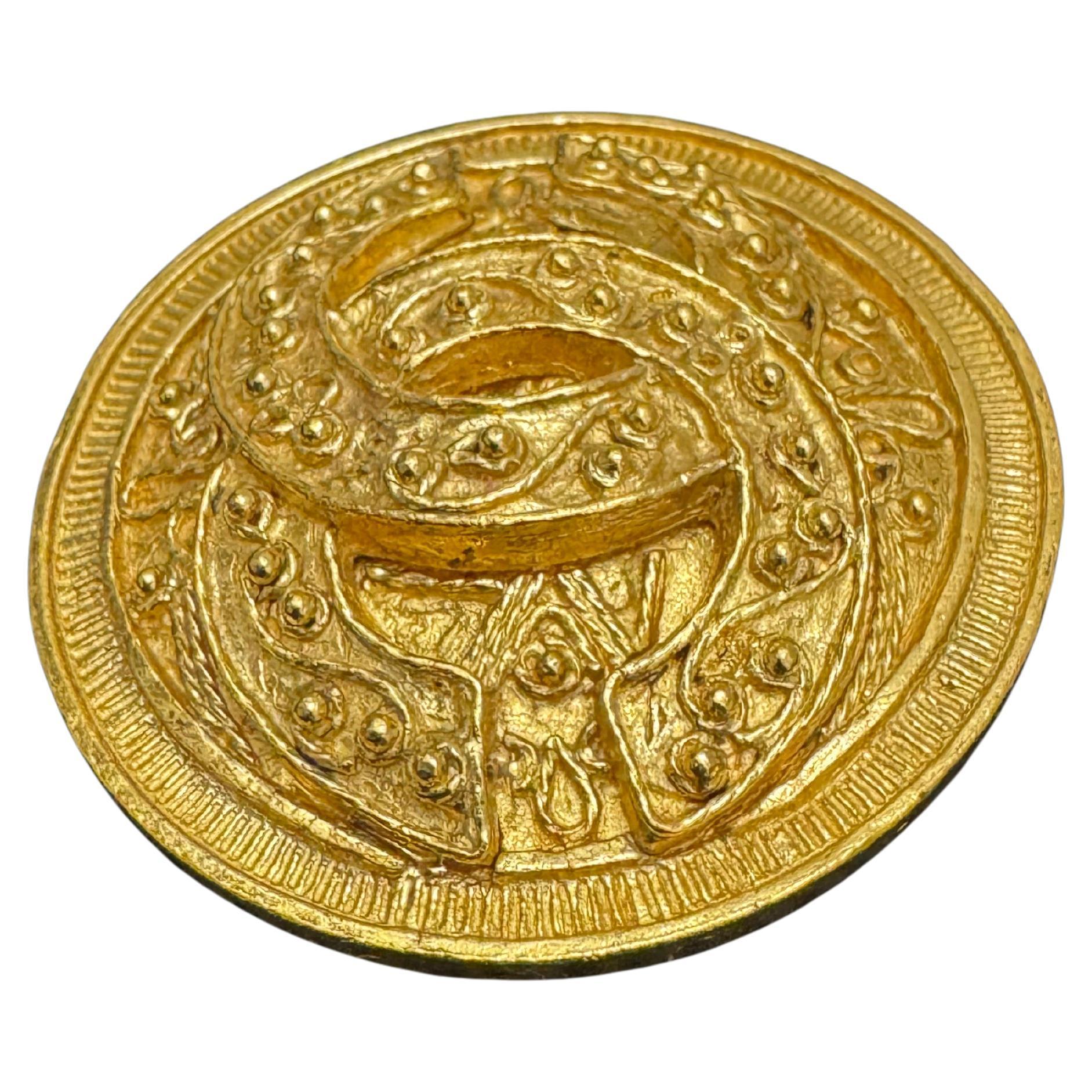 This vintage CHANEL gold toned brooch is crafted of gold plated metal featuring a CC logo. An exquisite vintage Chanel piece from the era of true workmanship. Stamped CHANEL 94A made in France. Measures approximately 5.2 cm in diameter. Comes with