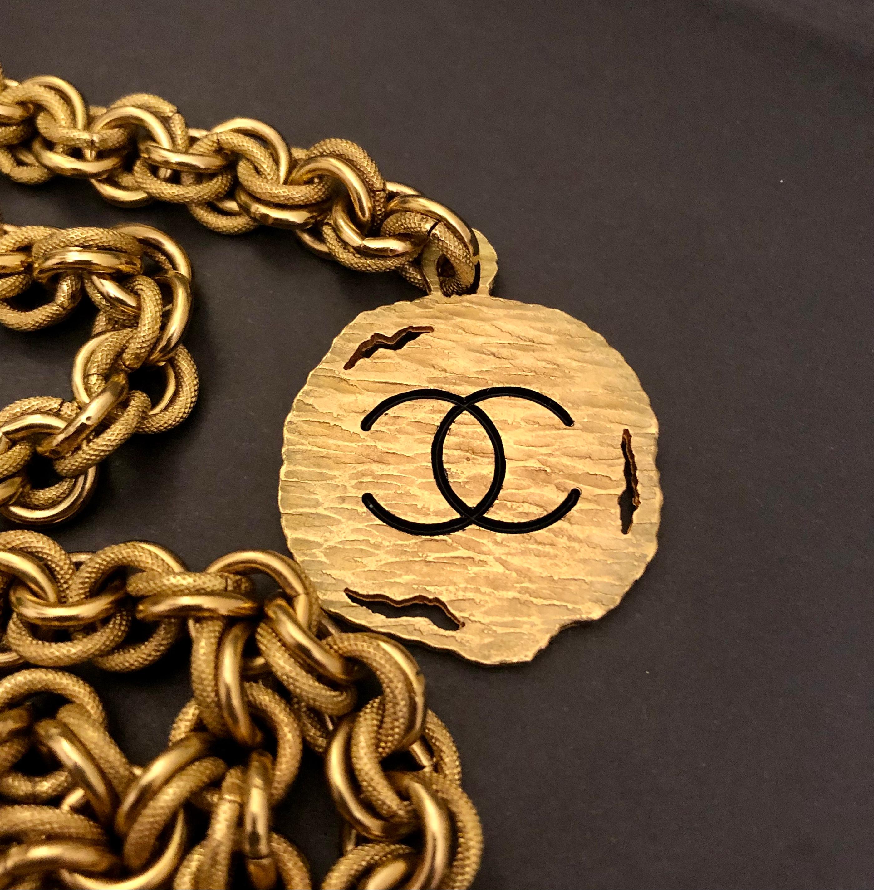 Vintage Chanel gold toned chain belt featuring front quadruple chain draping in textured and polished double links and a CC charm. Adjustable hook fastening. It can be worn as a belt or necklace. Stamped CHANEL 94A made in France. Chain length excl.