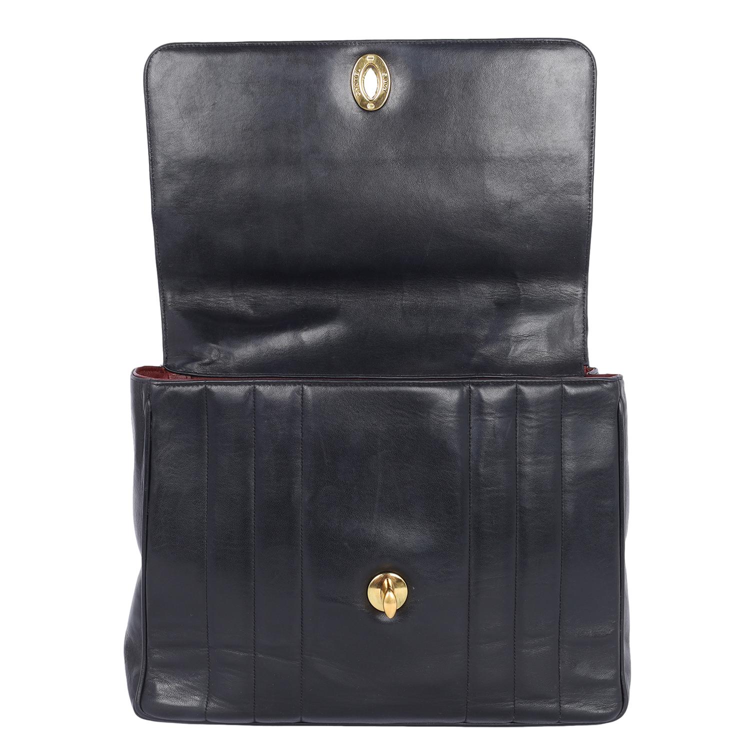 Authentic, pre-loved vintage Chanel mademoiselle Jumbo black front flap top handle bag. Features black lambskin leather, top handle, rear slip pocket, front flap closure, turn-lock, and large CC with 24kt gold plated hardware, the interior has a