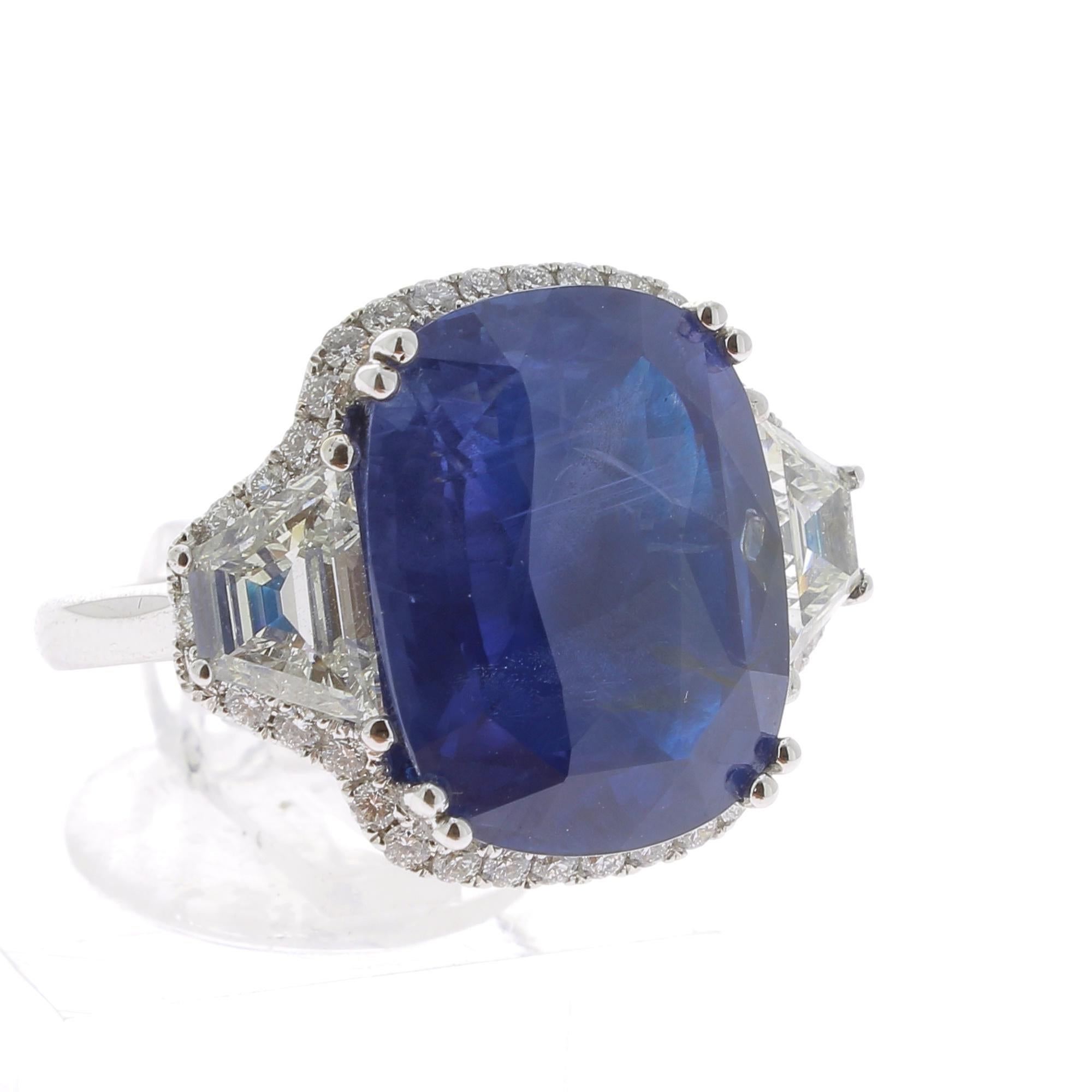 A Large and an amazing Cushion Ceylon Sapphire Ring, flanked on each side by a single Triangle Diamond and surround with an halo of Diamond weighing 0.48 Carats.
The total weight of the Ceylon  Sapphire ( or Sri Lanka Sapphire ) is 19.95 Carats.
The