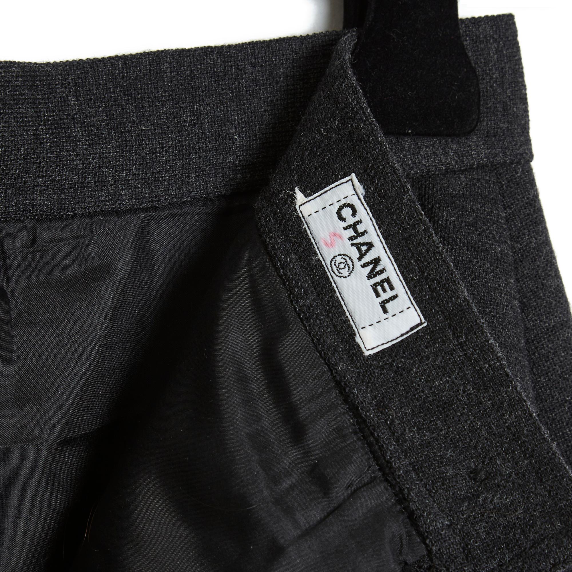 Chanel circa 1995 jupe droite en jersey de laine épais gris anthracite, fermée par un zip et un bouton au dos, doublée de soie assortie. Plus de Label de taille mais les mesures indiquent un 36FR : taille 35 cm, longueur 63,5 cm. La jupe est en très