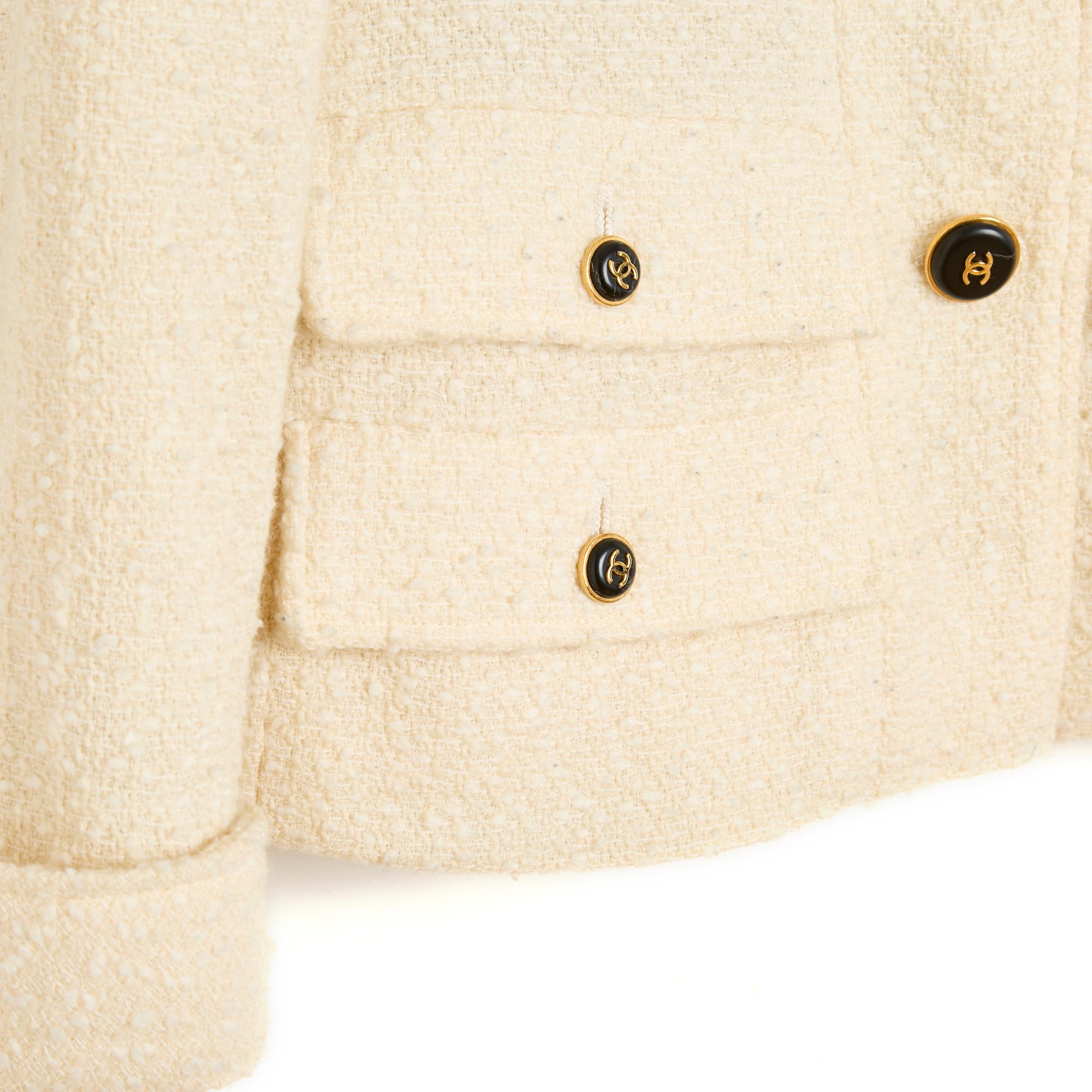 Chanel jacket from the AW1995 collection by Karl Lagerfeld in ecru wool, small notched collar closed with 4 CC-branded buttons in gold metal and contrasting glass paste, 4 buttoned flap pockets, long sleeves with small cuffs also closed with 2