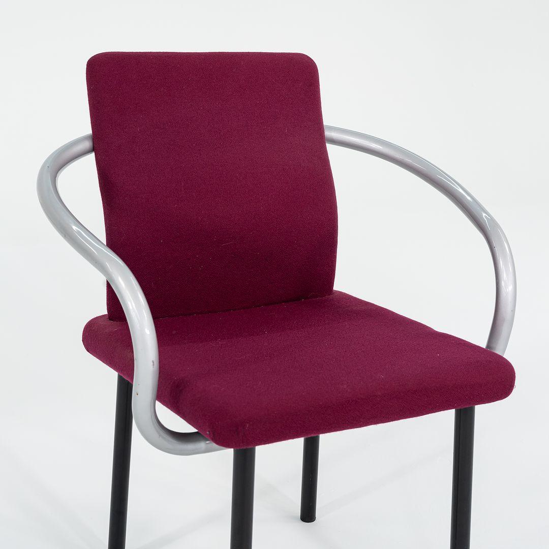 This is a Mandarin Chair, designed by Ettore Sottsass for Knoll in 1986. This chair dates to 1995. It has sculptural, silver enameled-steel arms, and has an upholstered seat & back in a dark pink fabric. It‚Äôs all about the arms on these chairs...