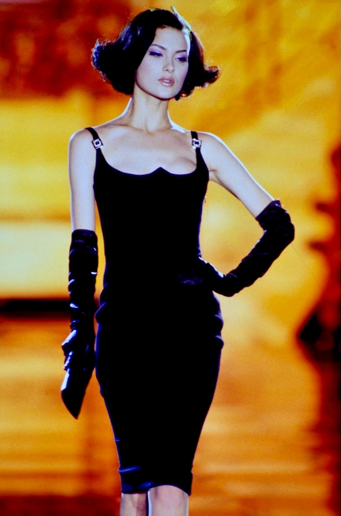 From 1995, this fitted black Gianni Versace dress debuted on the Spring season's Atelier Versace runway, modeled by Shalom Harlow. This dress was further highlighted by model Claudia Mason on the April 1995 cover of Vogue España, captured by Steven