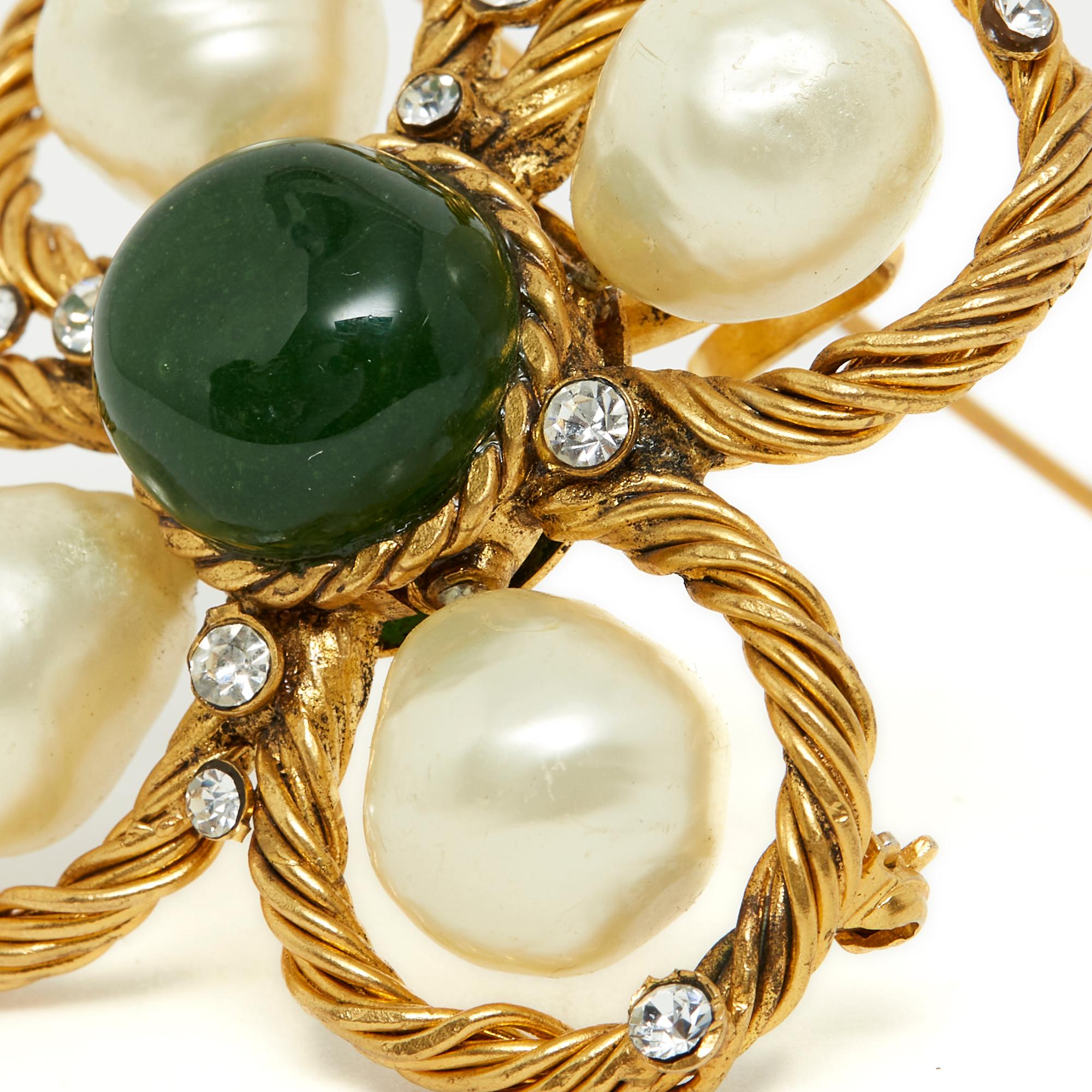 Broche Chanel Haute Couture par Gripoix, probablement vers 1995 en métal doré, perles de verre nacré irrégulières, strass blancs et cabochon de verre vert, munie d'une épingle à broche et d'une anse pour être suspendue à un collier, un décolleté,