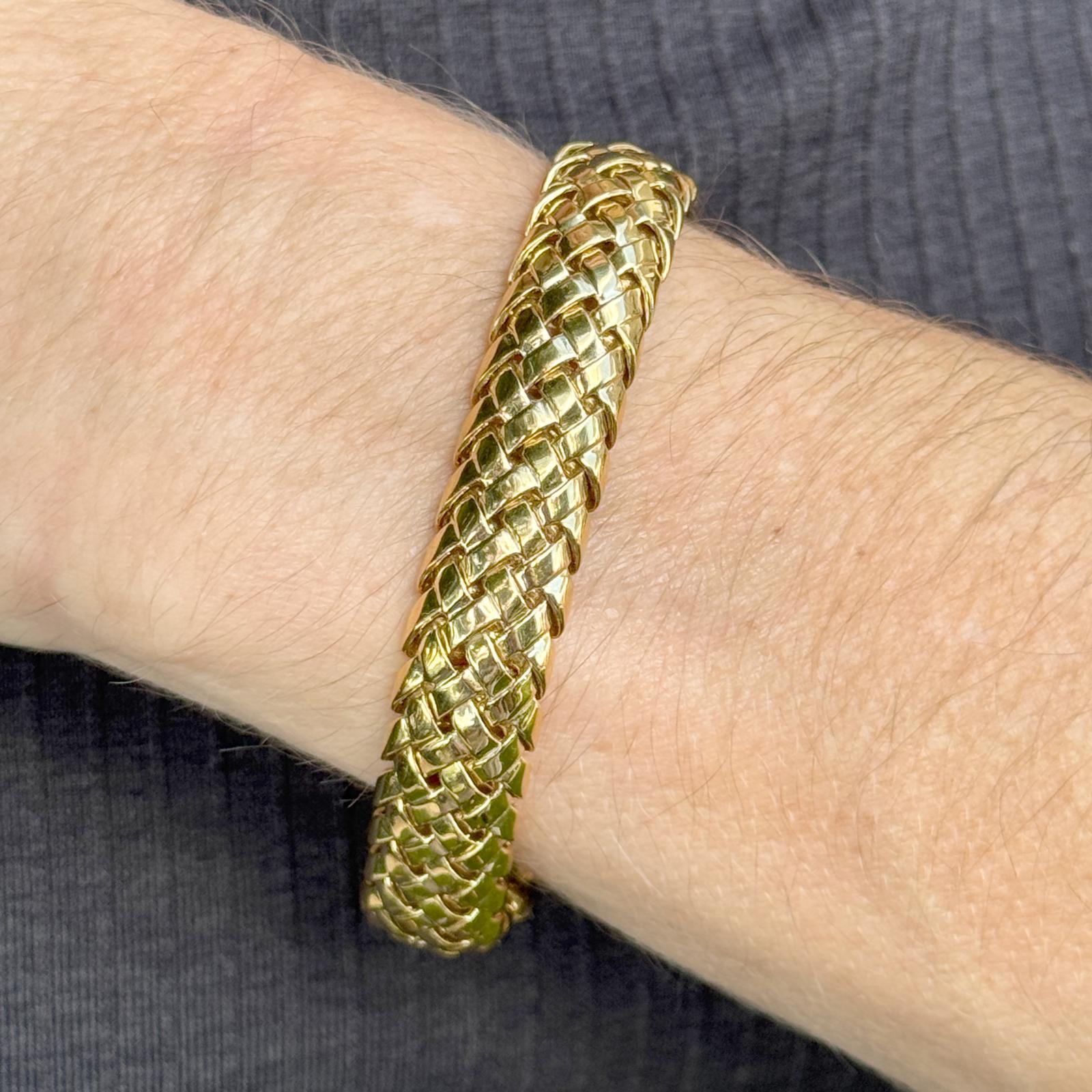 Confectionné par Tiffany & Co, cet élégant bracelet Vannerie en or jaune 18 carats présente le motif tissé emblématique de la maison, symbole d'un savoir-faire et d'une sophistication intemporels. Mesurant 7 pouces de long et 0,45 pouce de large, il