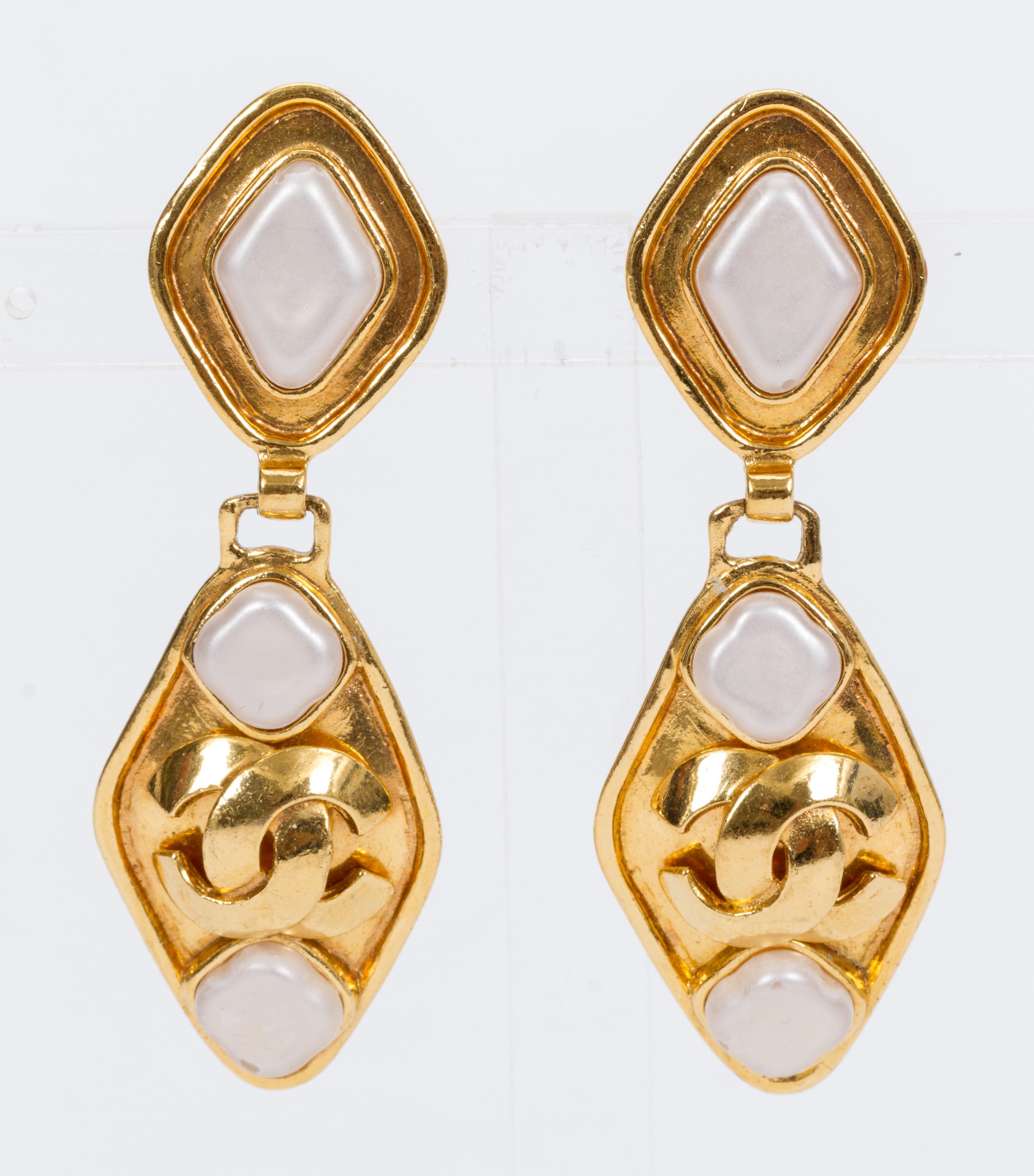 Chanel gold-plated drop clip-back earrings with mother-of-pearl-colored poured glass stones. Comes with original pouch. Minor wear.