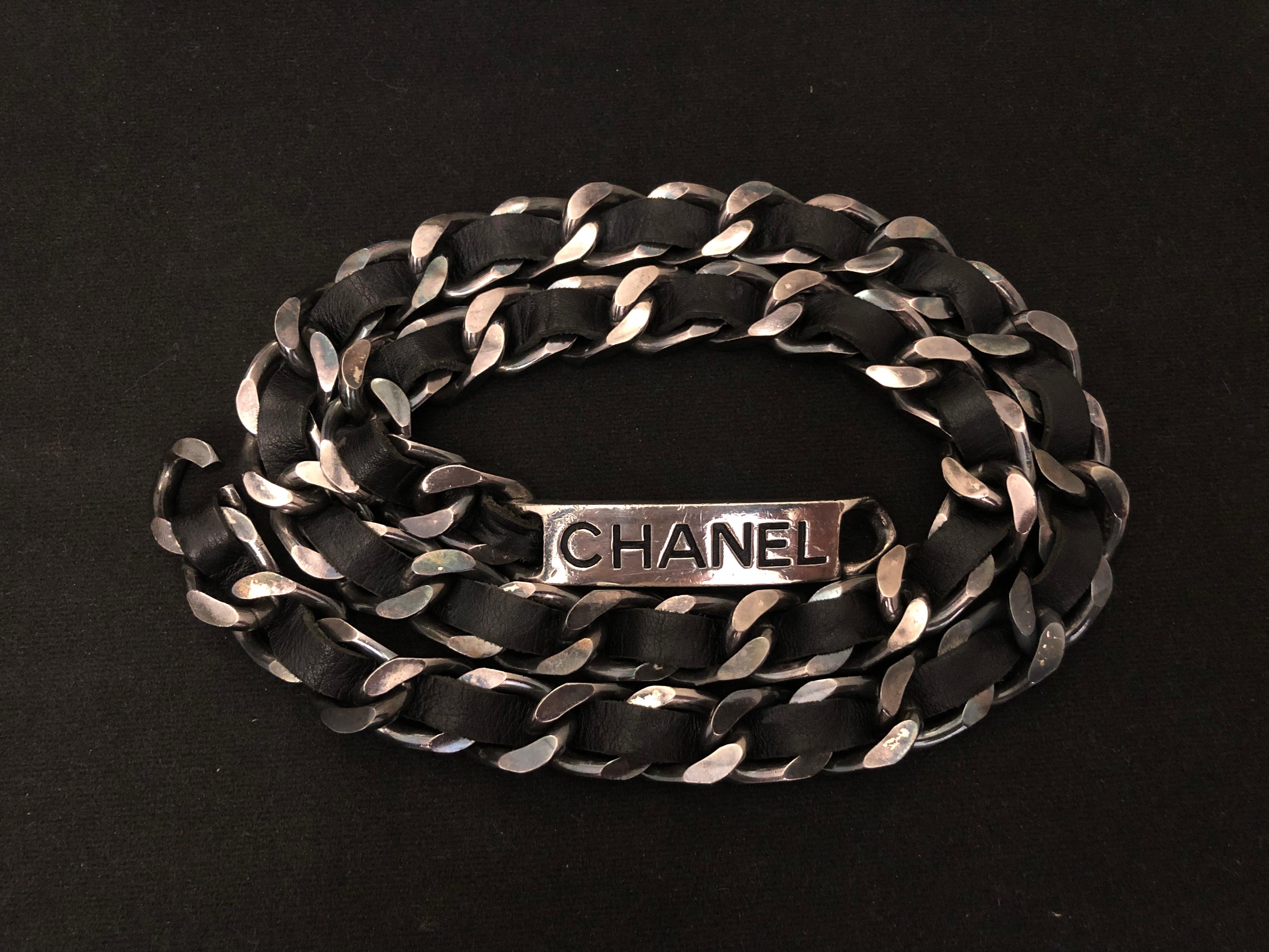 Vintage CHANEL lambskin leather chain belt in black and silver. This rugged and stylish belt is crafted of sturdy silver toned chain link interlaced with black lambskin leather. It features a CHANEL letter plaque on the front. Hook fastening.