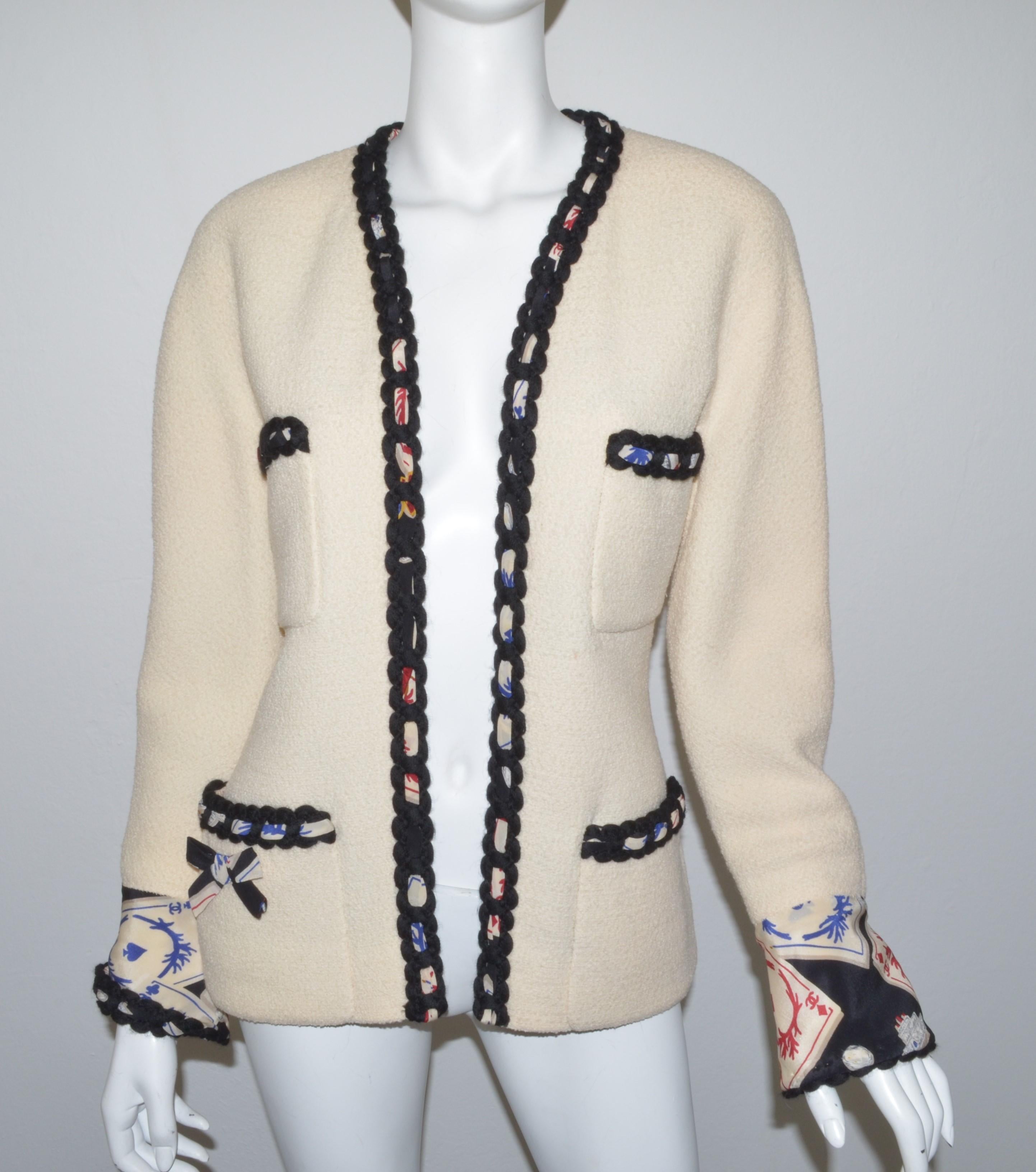 1995 Vintage Chanel Tweed Jacket with Playing Cards Motif -- Jacket is featured in a cream color with a black knitted trimming and playing cards motif lining. Jacket has two functional front pockets and full lining. Excellent condition with a very