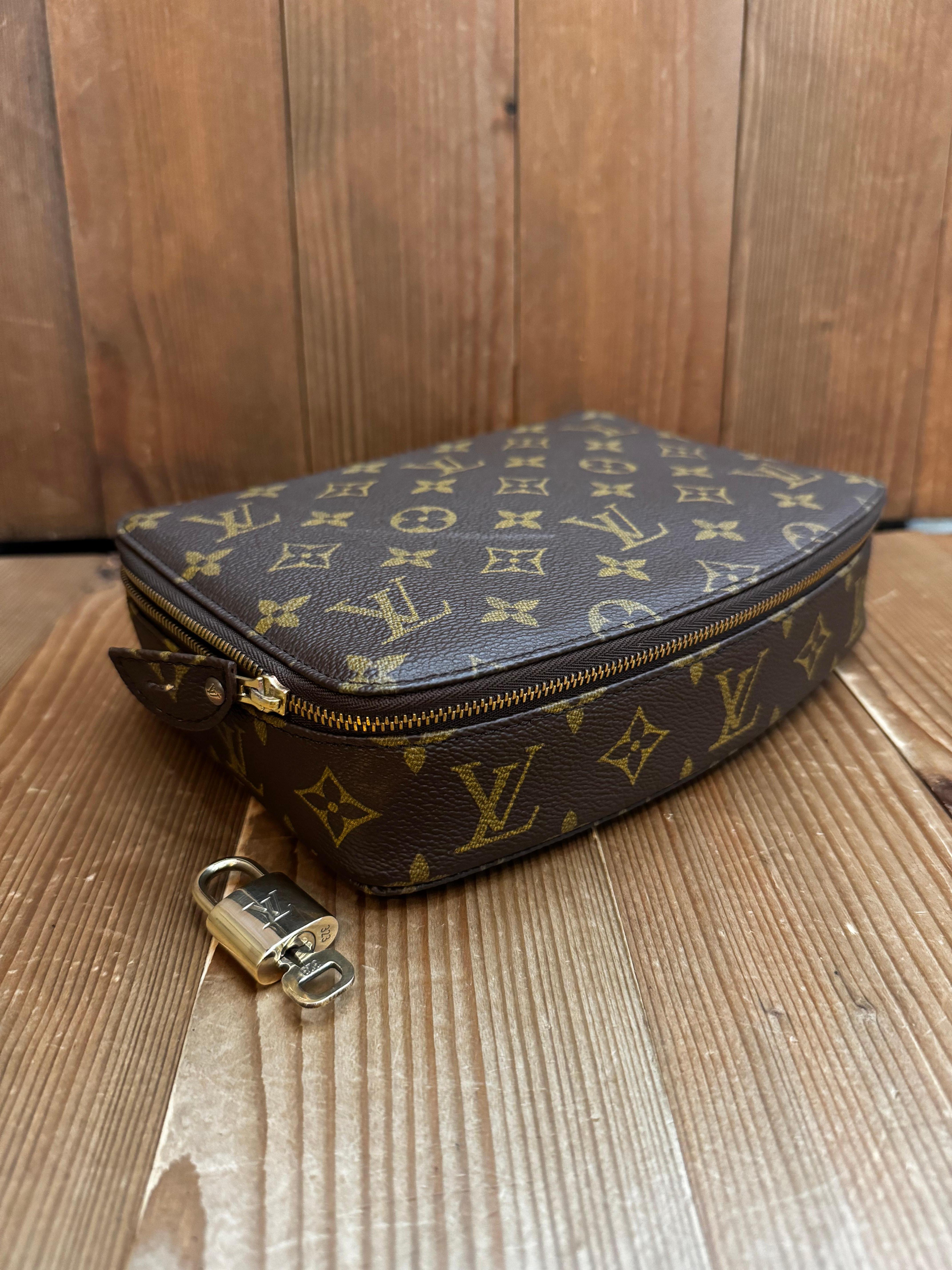 This vintage LOUIS VUITTON jewelry case is crafted of brown monogram canvas. Top zip-around closure opens to a felt interior in beige featuring three zippered pouches and a monogram canvas flap with snap fastening to hold your favorite earrings.