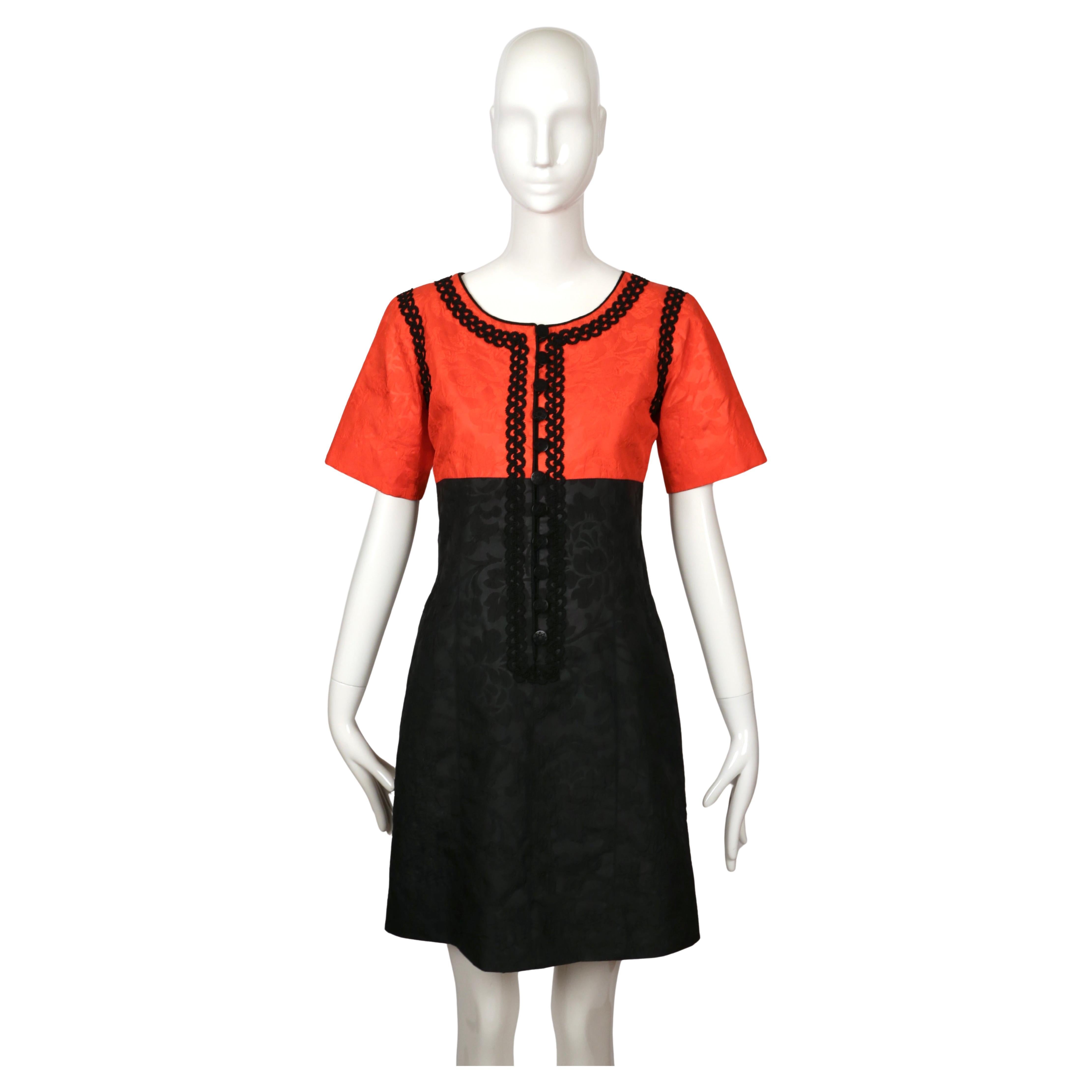 Very rare silk mini dress by Yves Saint Laurent from the Cruise 1995 collection. The dress features a vivid red bodice paired with a black skirt in a special silk fabric printed with a lace pattern and textured with raised portions for depth.  The