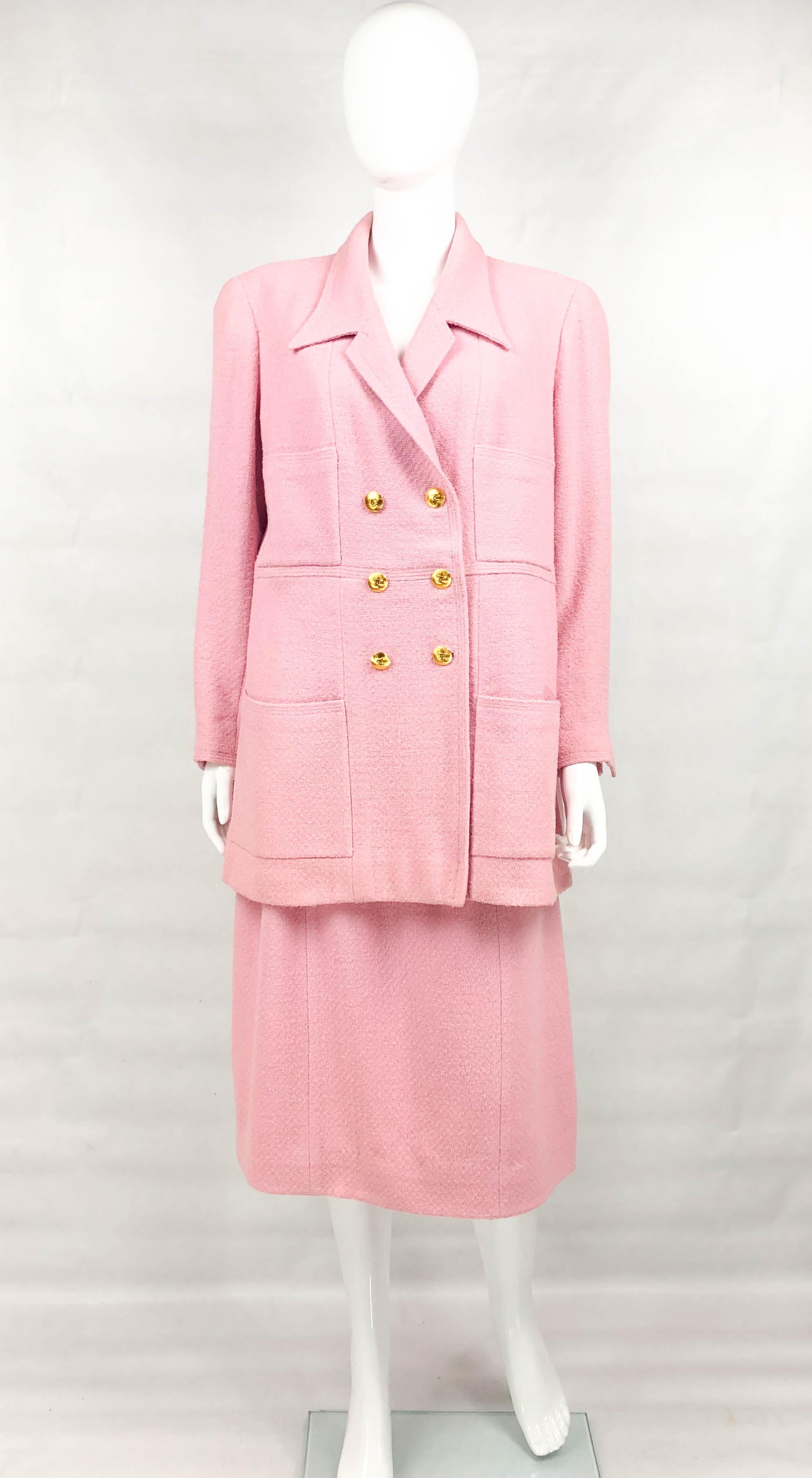 Vintage Chanel Pink Wool Suit with Logo Buttons. This stylish ensemble by Chanel was created for the 1996 Cruise Collection. Made in pink wool and lined in silk, it features 4 large pockets on the front. The round gilt ribbed buttons bear the iconic